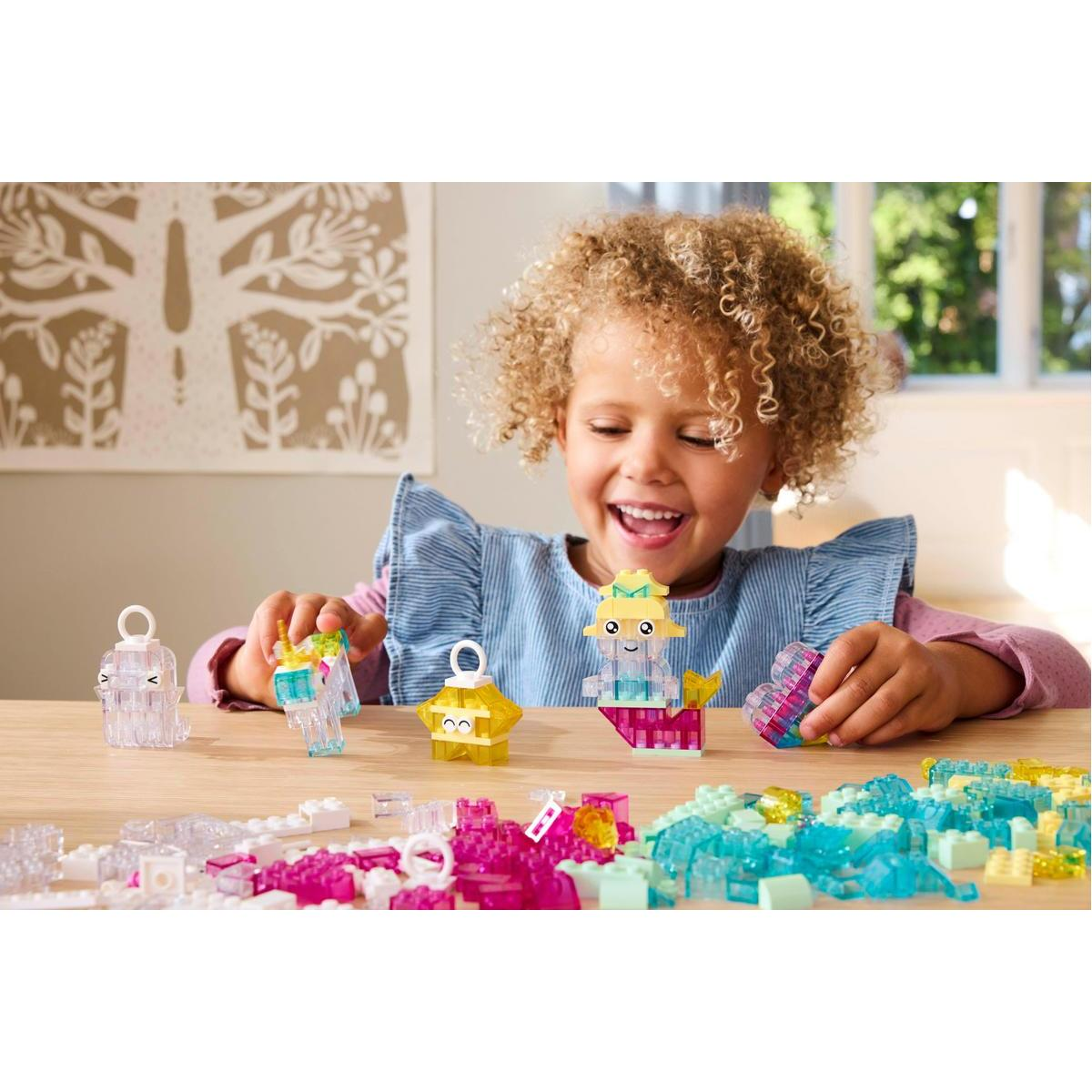 Mała dziewczynka bawi się zestawem Lego z błyszczącymi i kolorowymi strukturami przypominającymi kryształy.