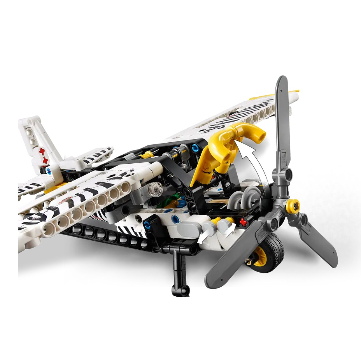 Zbliżenie wnętrza samolotu Lego. Samolot ma paski zebry, żółte detale i obracające się śmigło.