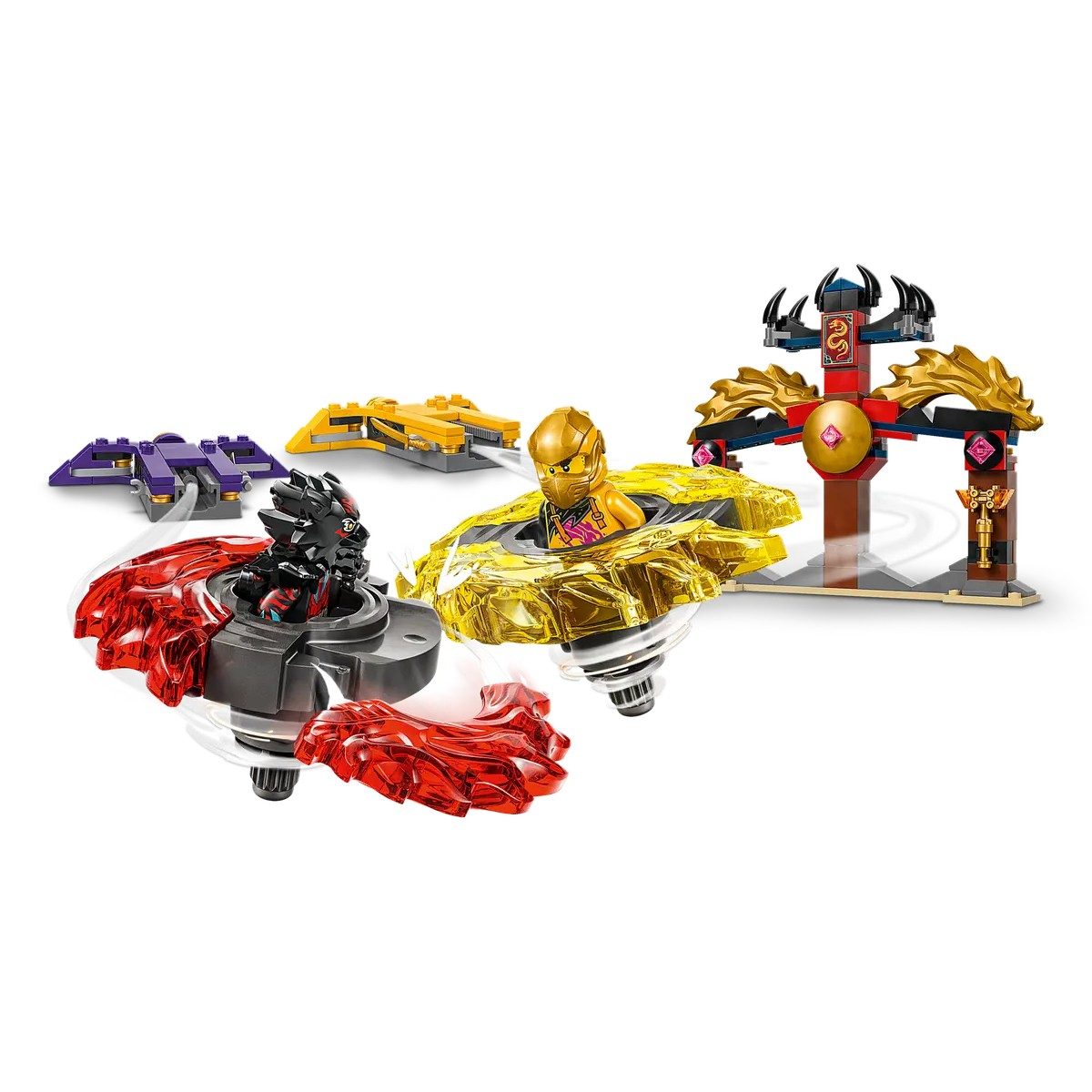Tres peonzas Lego girando en un juego. Una es negra, otra amarilla y otra roja, sobre un fondo blanco.