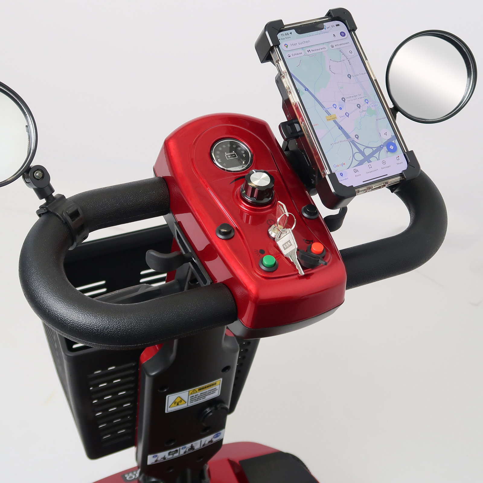 Nahaufnahme des Bedienfelds eines roten Mobilitätsrollers mit Telefonhalter.