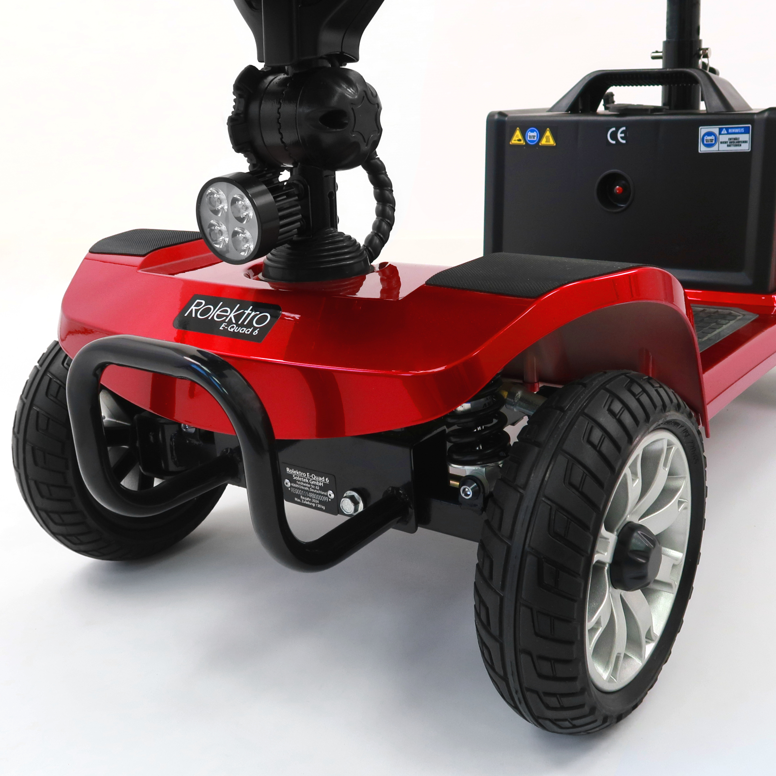 Nahaufnahme eines roten Mobilitätsrollers mit Scheinwerfer und Vorderrädern.