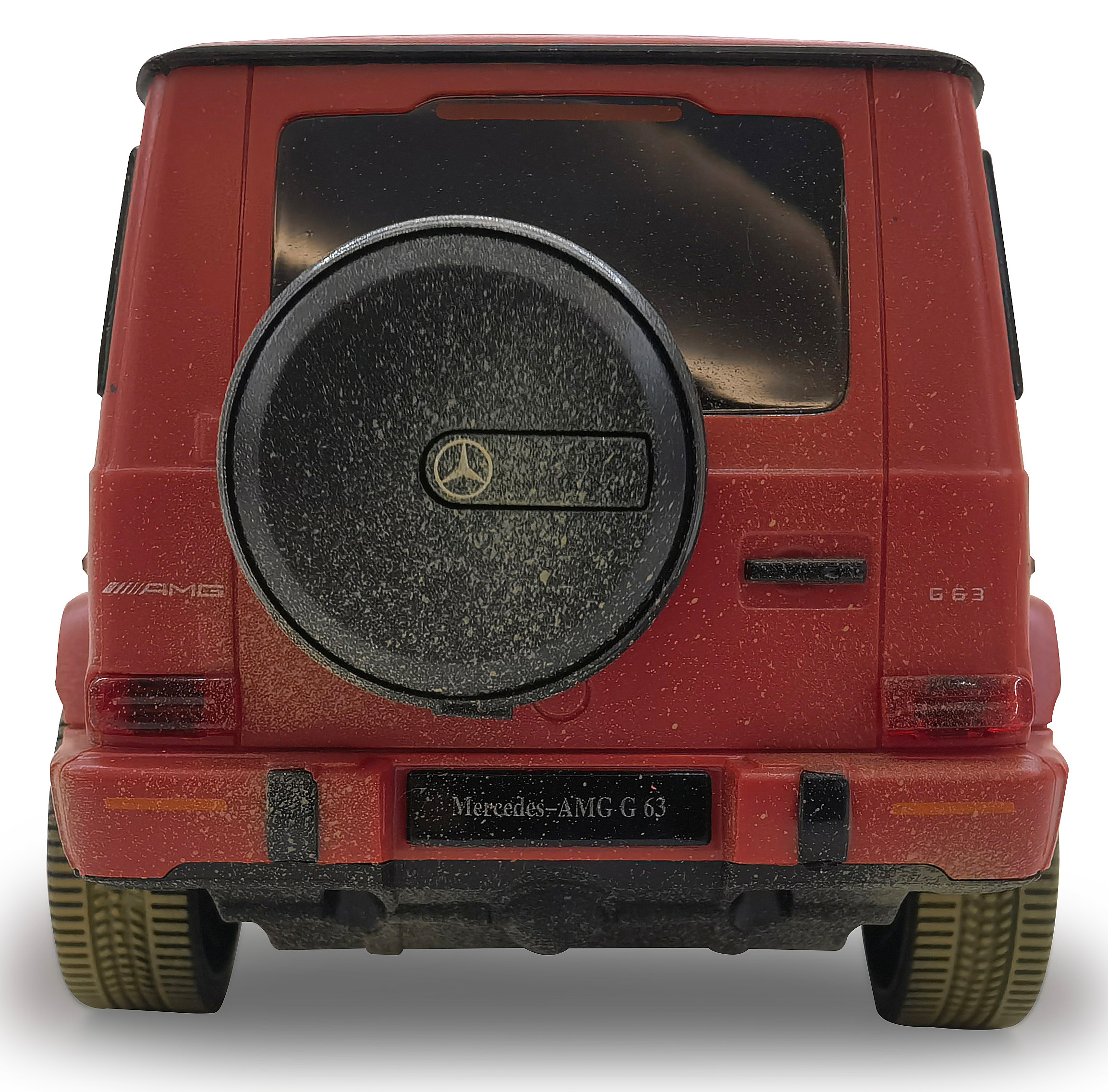 Rückansicht eines roten Spielzeug-Mercedes-AMG G 63. Reserverad hinten, schwarze Akzente und schmutziges Aussehen.