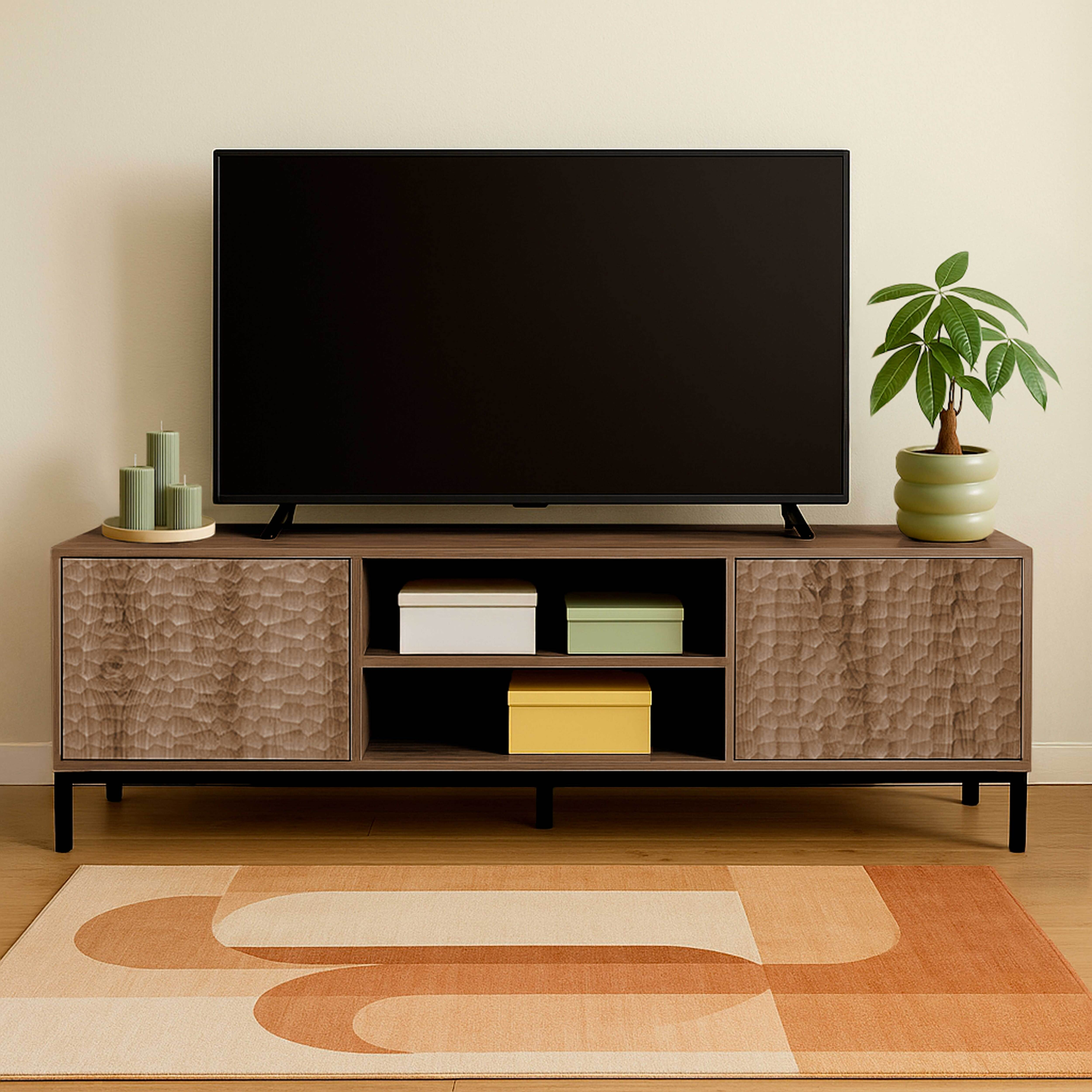 Wohnzimmer-Setup. TV auf Holzschrank mit drei Boxen, Kunst, Teppich und Topfpflanze.