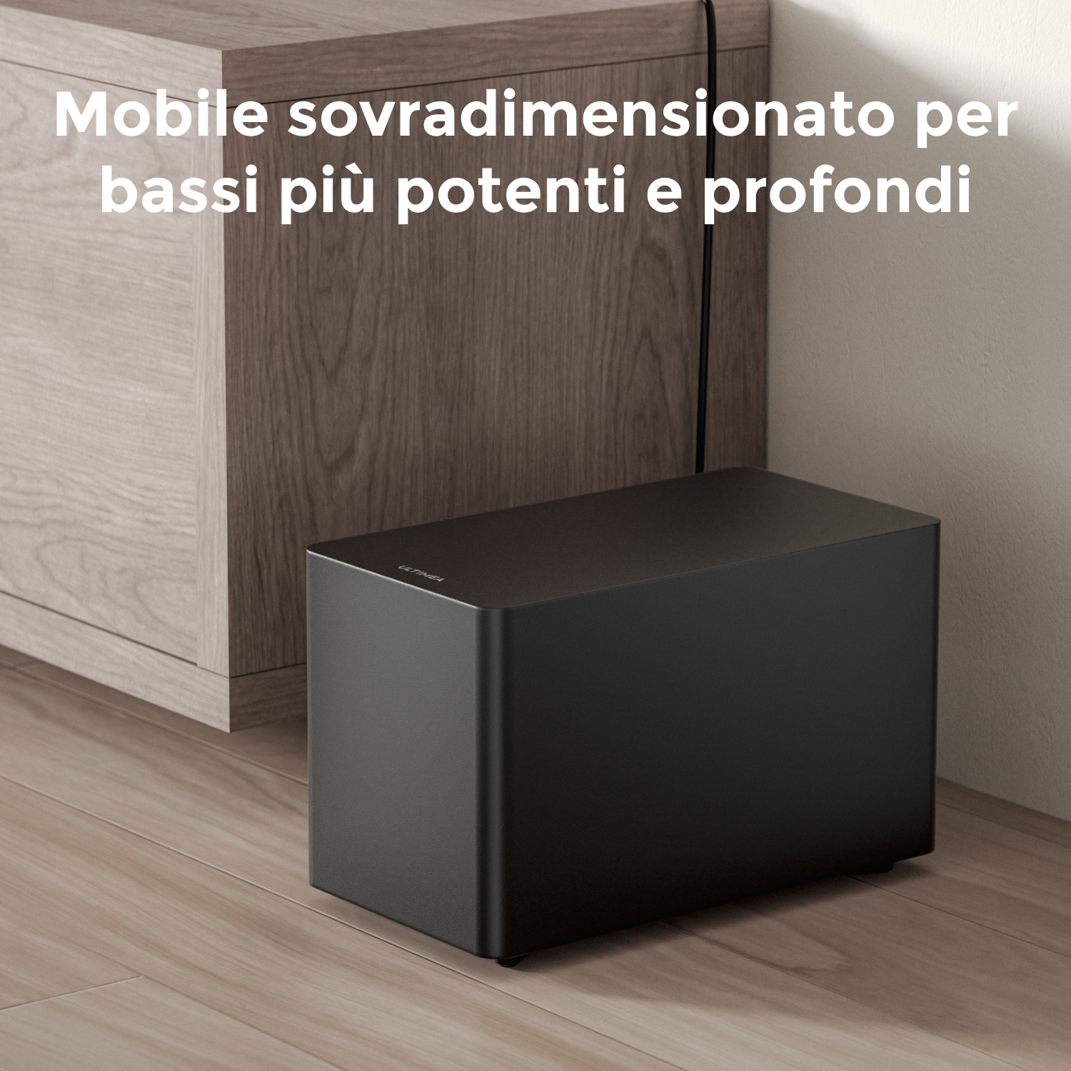 Un subwoofer nero è appoggiato su un pavimento in legno accanto a un mobile in legno.