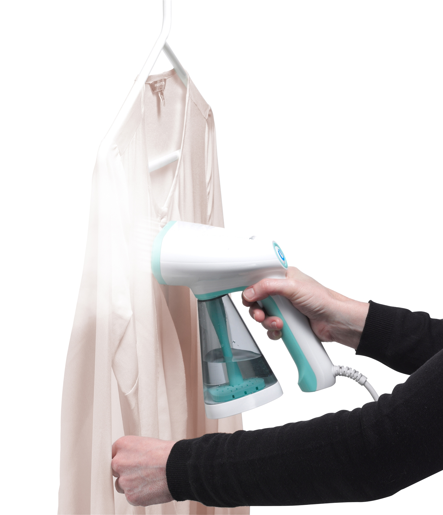 Eine Frau dämpft ein hellrosa Hemd mit einem weißen und teal Dampfer. Das Hemd hängt an einem weißen Bügel.
