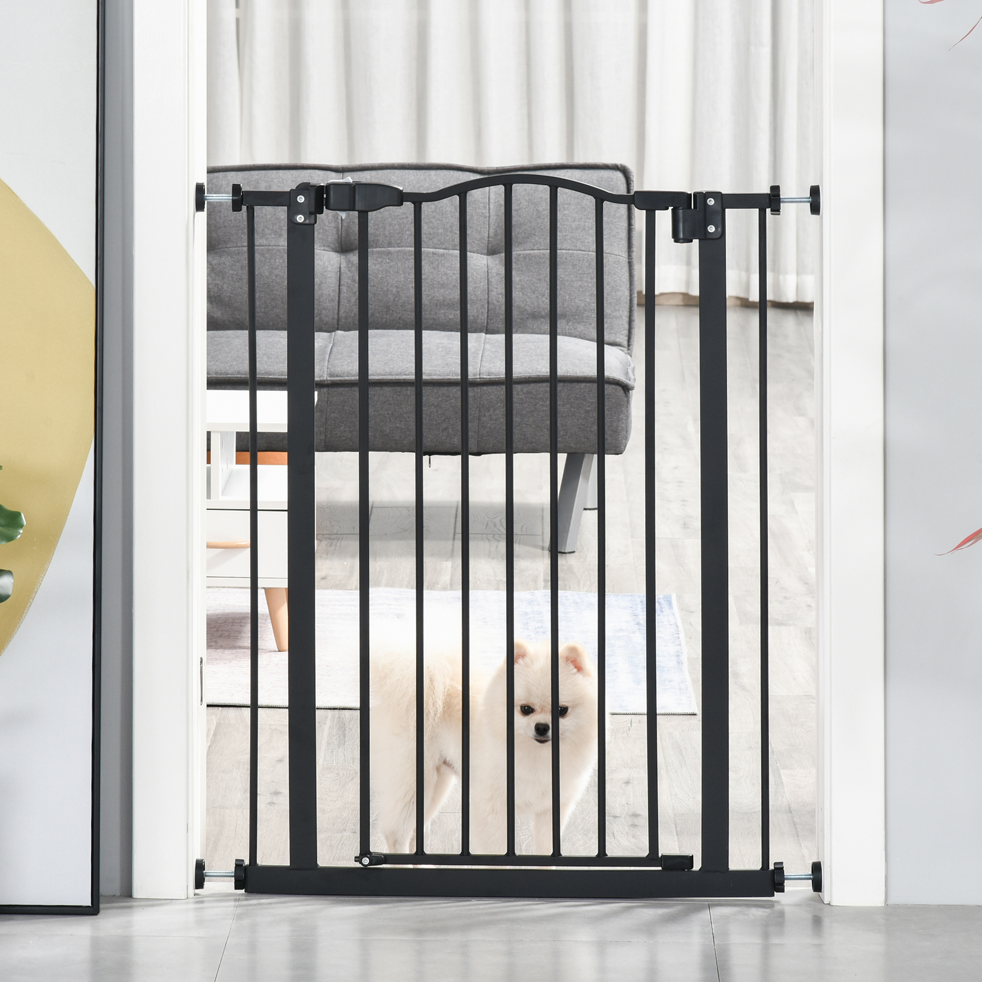 Una puerta de metal negro instalada en una puerta, con un perro blanco en primer plano.