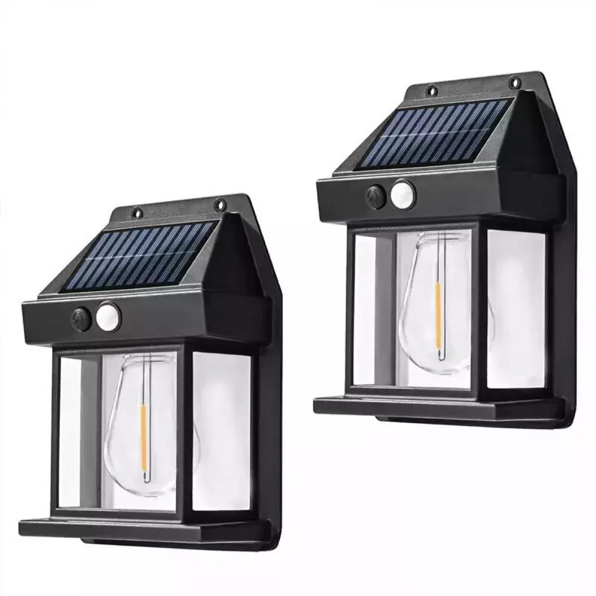 Zwei schwarze Solarleuchten an einer weißen Wand. Jede hat ein Solarpanel und ein Licht.