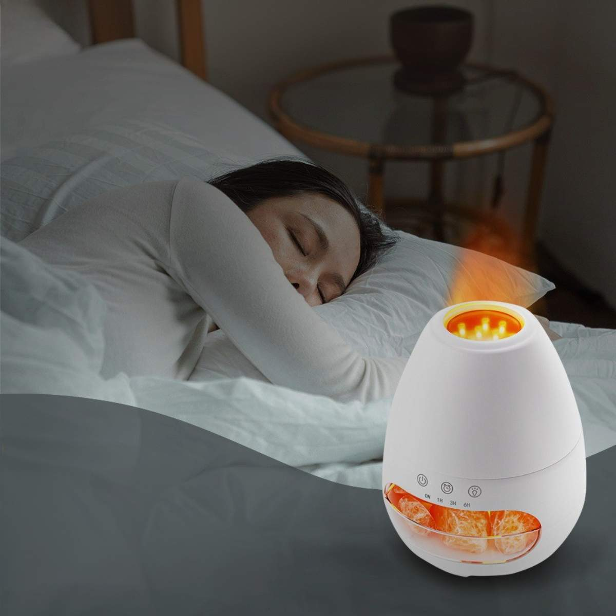 Eine Frau schläft in der Nähe eines weißen Luftbefeuchters mit warmem Licht auf einem weißen Bett.