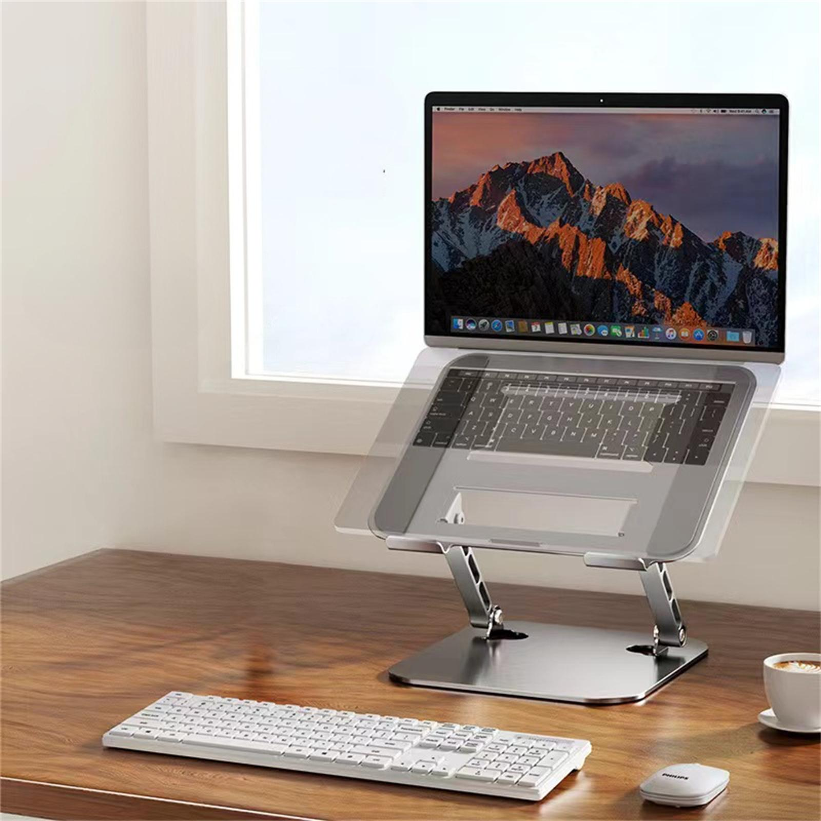 Laptop auf einem Ständer auf einem Schreibtisch mit weißer Tastatur und Maus.