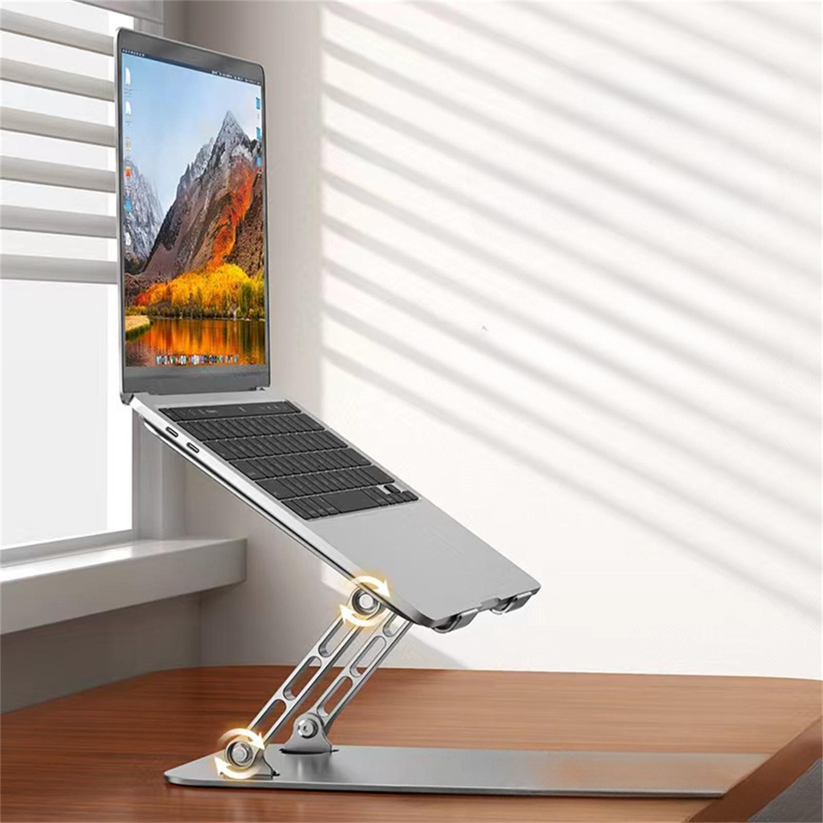 Ein Laptop ist auf einem silbernen Ständer montiert, nach oben abgewinkelt. Der Ständer steht auf einem Holztisch.