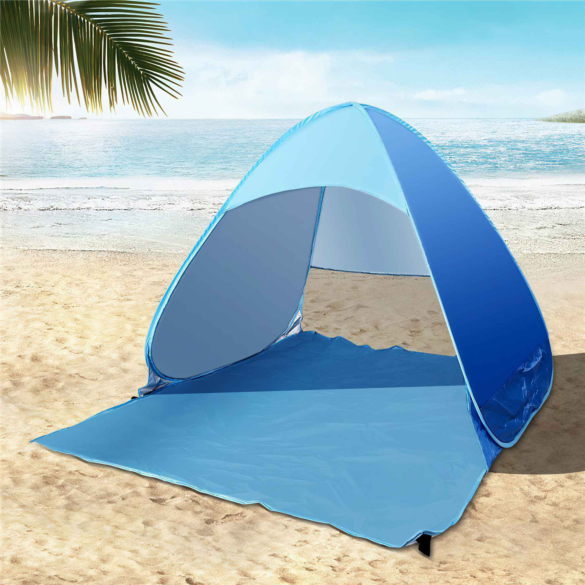 Ein blaues Strandzelt ist an einem Sandstrand in der Nähe des Meeres aufgebaut.