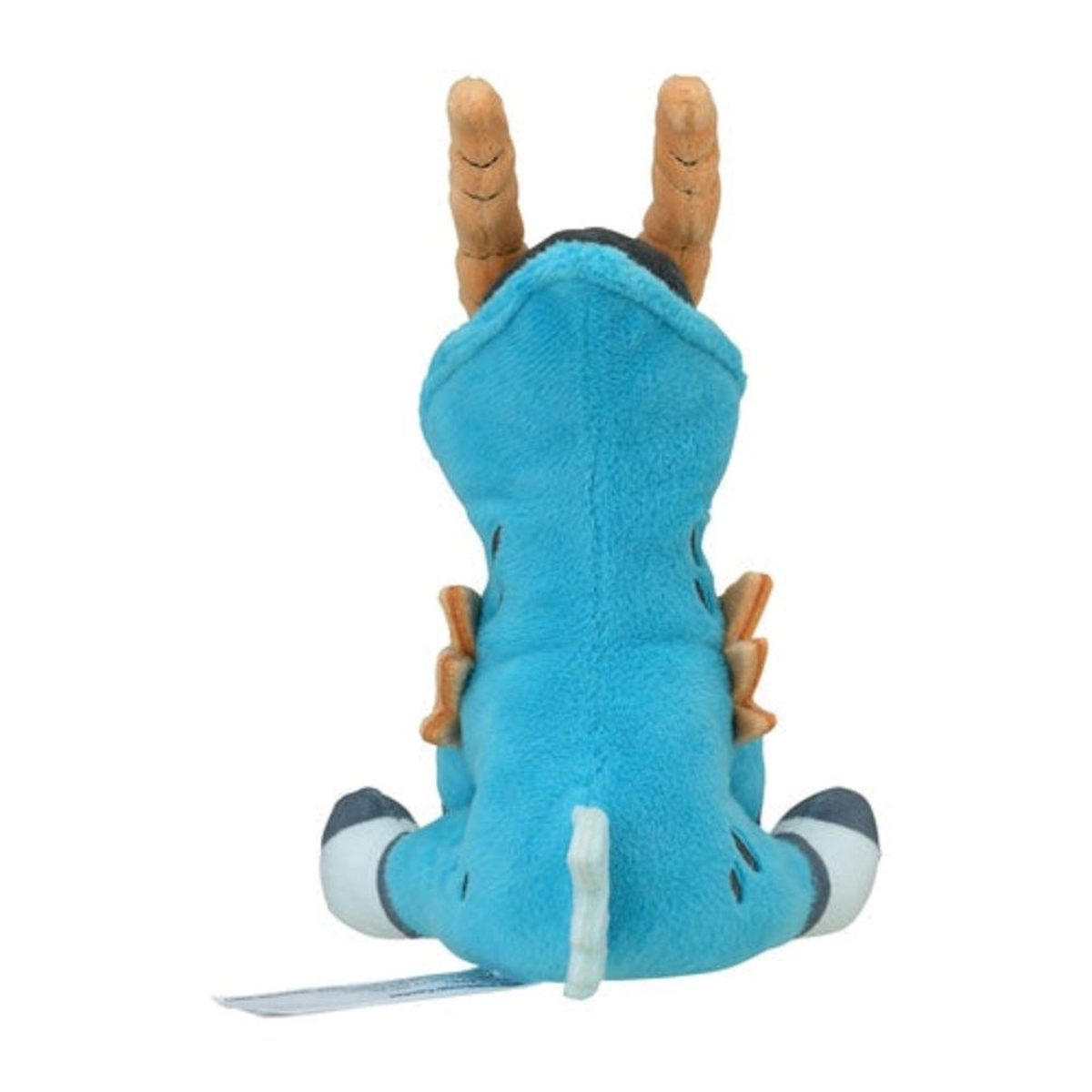 Blaues Plüschtier mit orangen Hörnern, kleinen schwarzen Flecken und einem weißen Schwanz. Es wird von hinten gesehen.