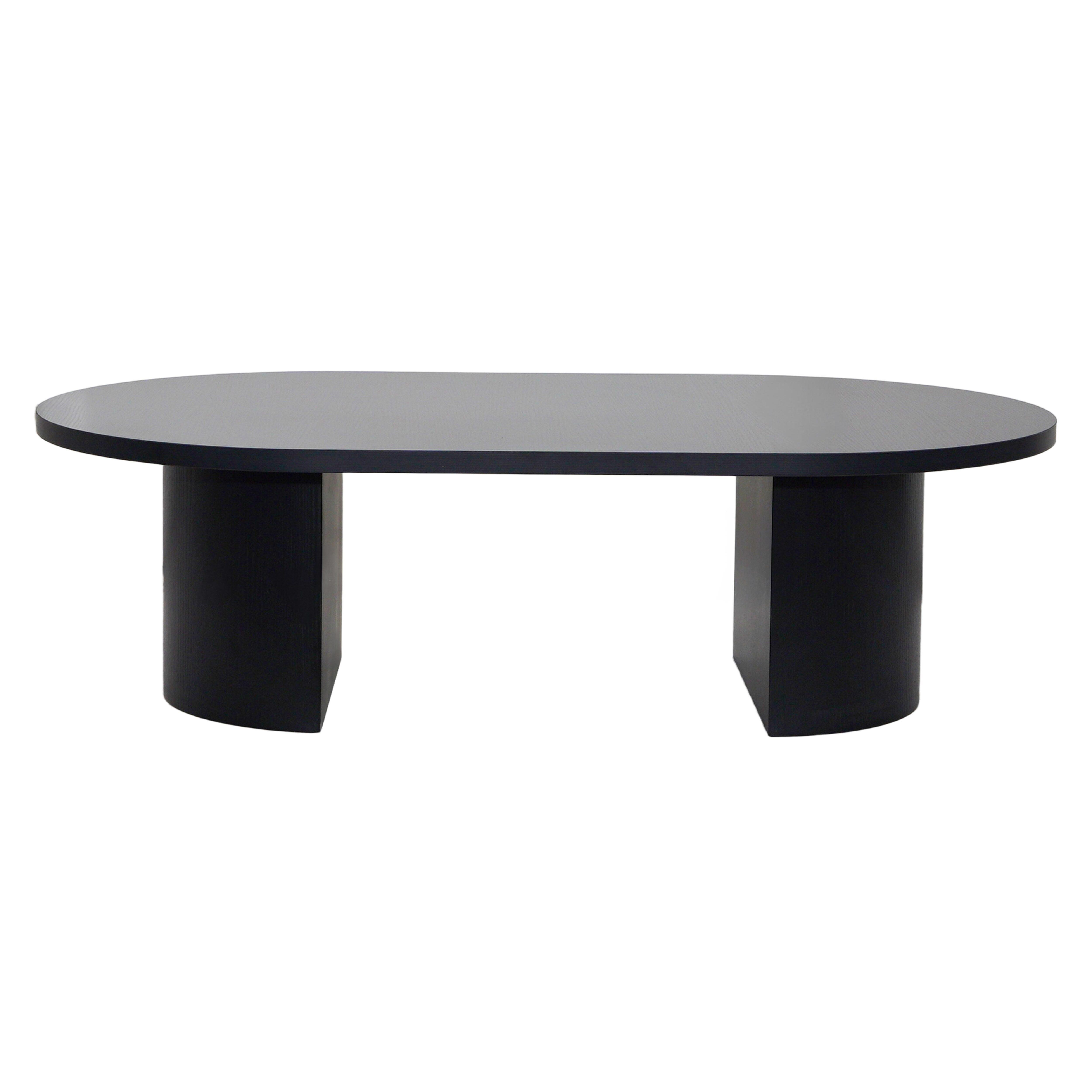 Ein ovaler schwarzer Tisch mit zwei zylindrischen Beinen, zentriert auf einem weißen Hintergrund, der sein modernes Design zeigt.