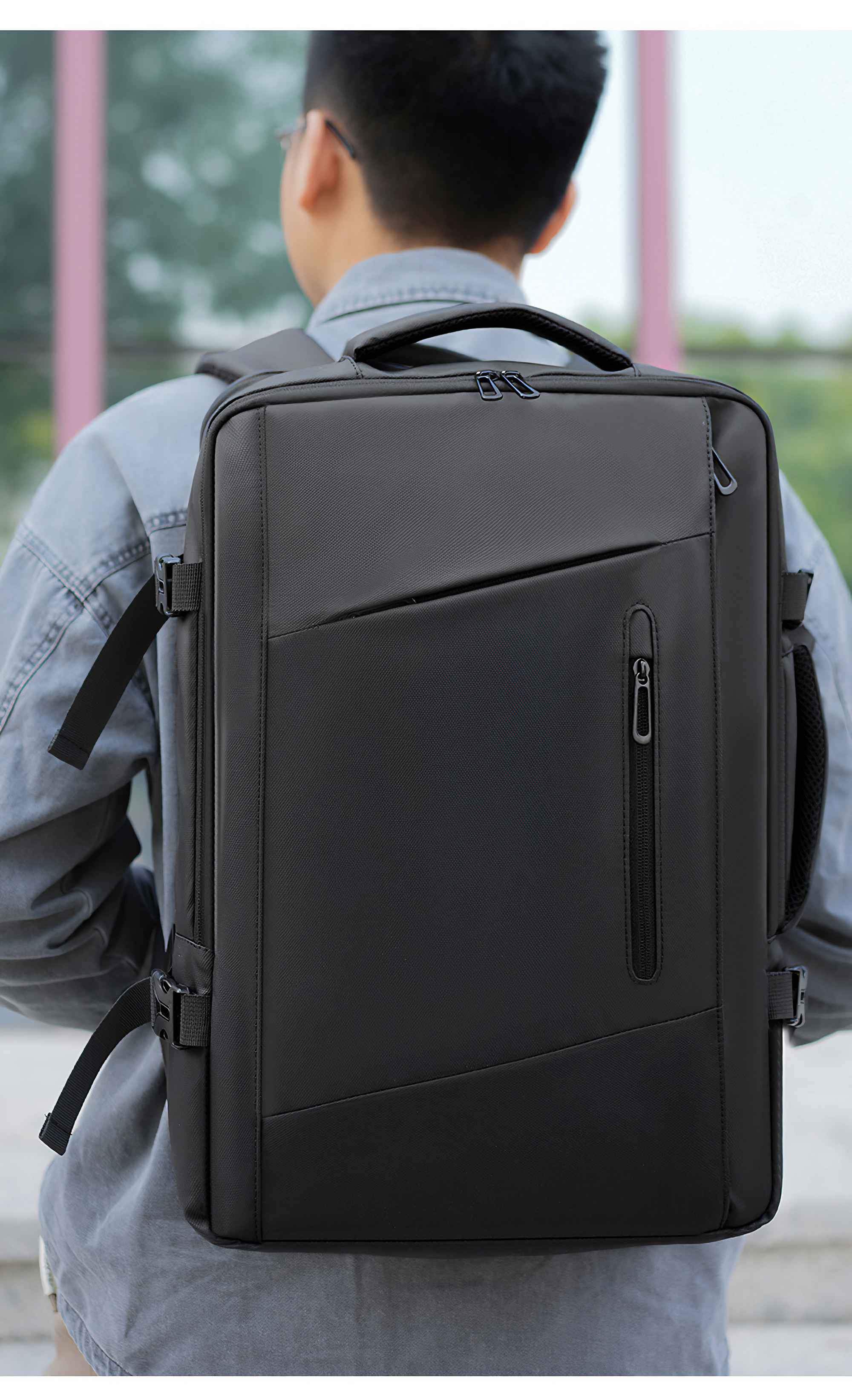 Ein Mann mit einem schwarzen Rucksack, von hinten gesehen. Der Rucksack ist schwarz und glatt.