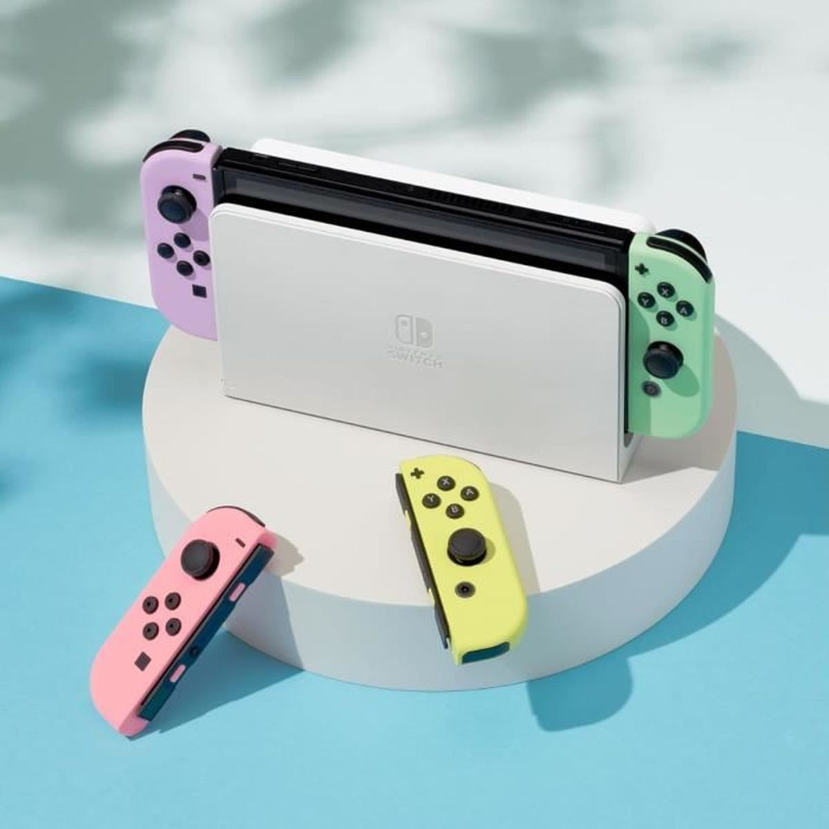 Nintendo Switch-Konsole mit bunten Joy-Cons. Zwei Joy-Cons an der Konsole und zwei getrennt auf einem Ständer.