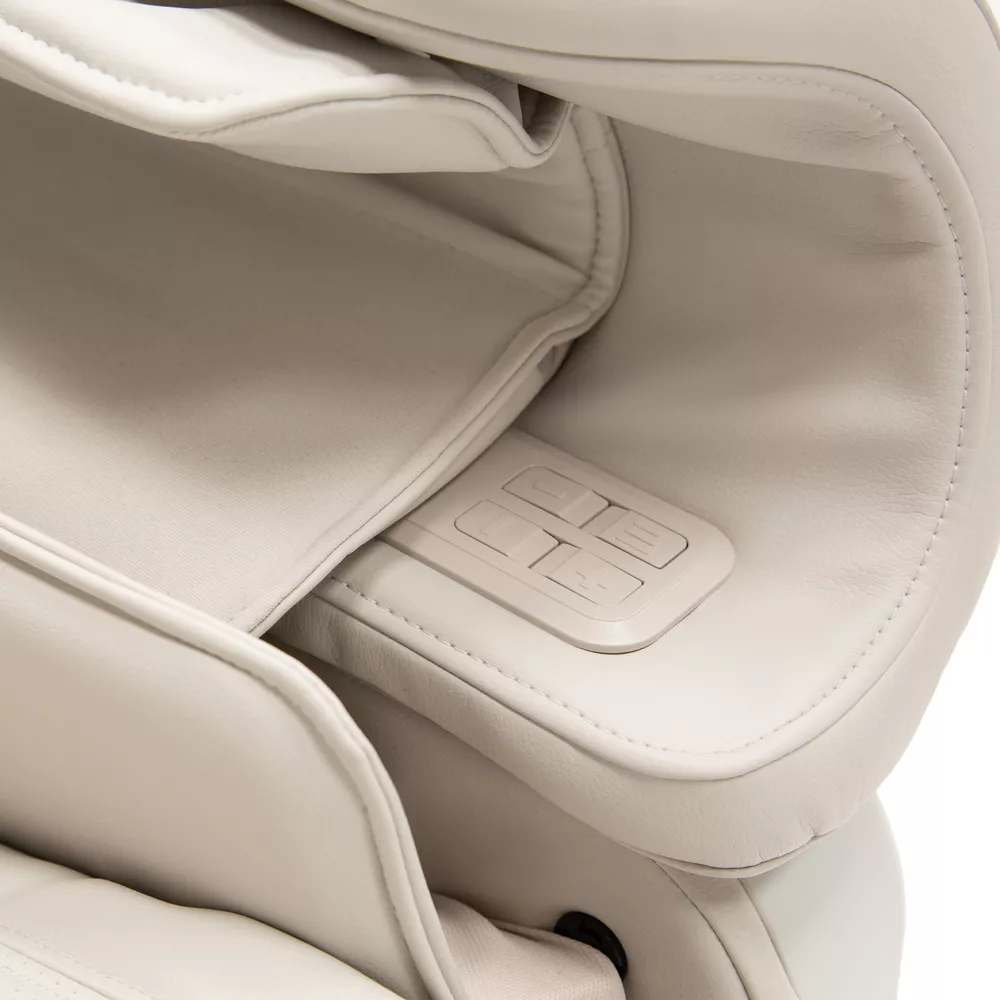 Close-up of a massage chair control panel. The chair is white and the panel has buttons.