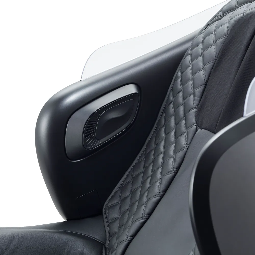 Gros plan sur l'accoudoir noir d'un fauteuil de massage avec coussin en losange.