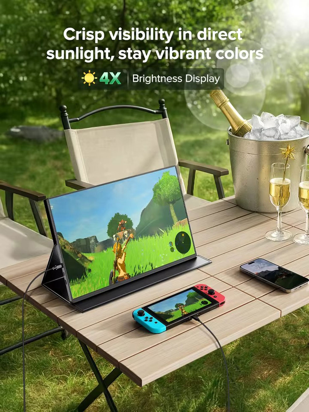 Un monitor está sobre una mesa con un juego. Un teléfono y champán están al lado.