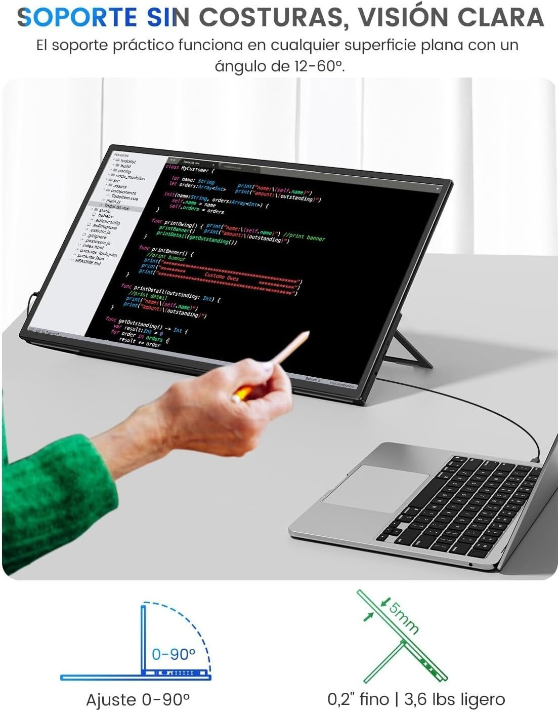 Un monitor mostrando código, apoyado por un portátil. Mano sosteniendo un lápiz. Soporte ajustable.
