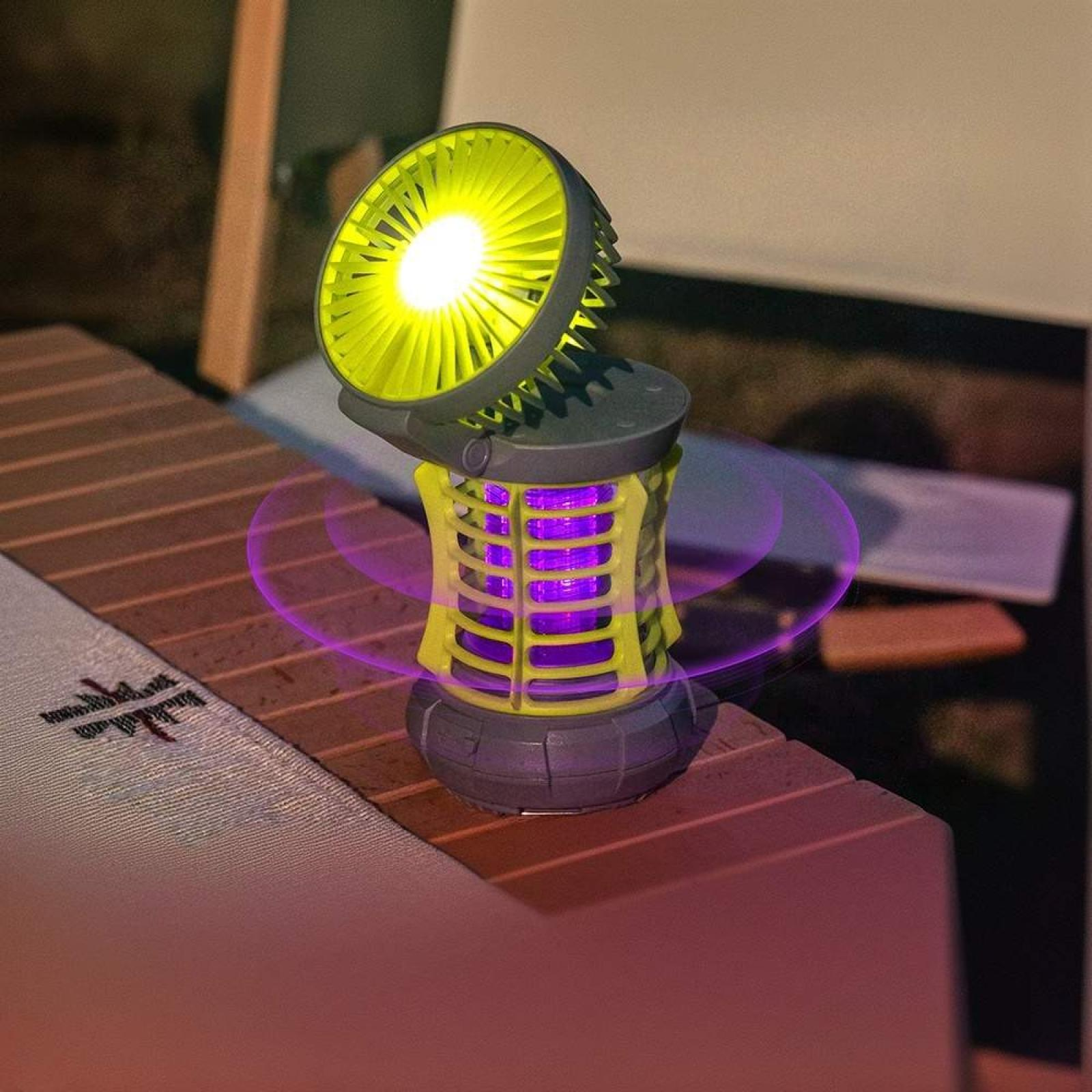 Ein gelbes und graues Mückenschutzgerät mit Ventilator und Licht, das auf einer Holzoberfläche steht.