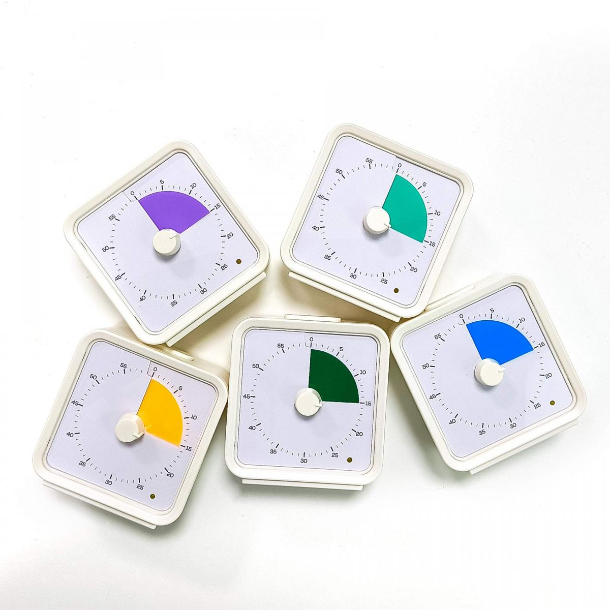 Fünf weiße Timer, jeder mit einem farbigen Zifferblatt und einem weißen Knopf, sind auf einer weißen Oberfläche angeordnet.