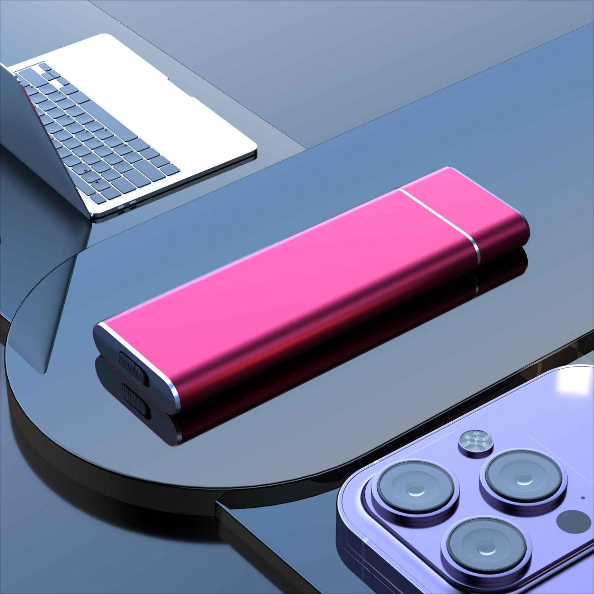 Eine pinkfarbene externe Festplatte und ein Telefon befinden sich auf einer reflektierenden Oberfläche, im Hintergrund ein Laptop.