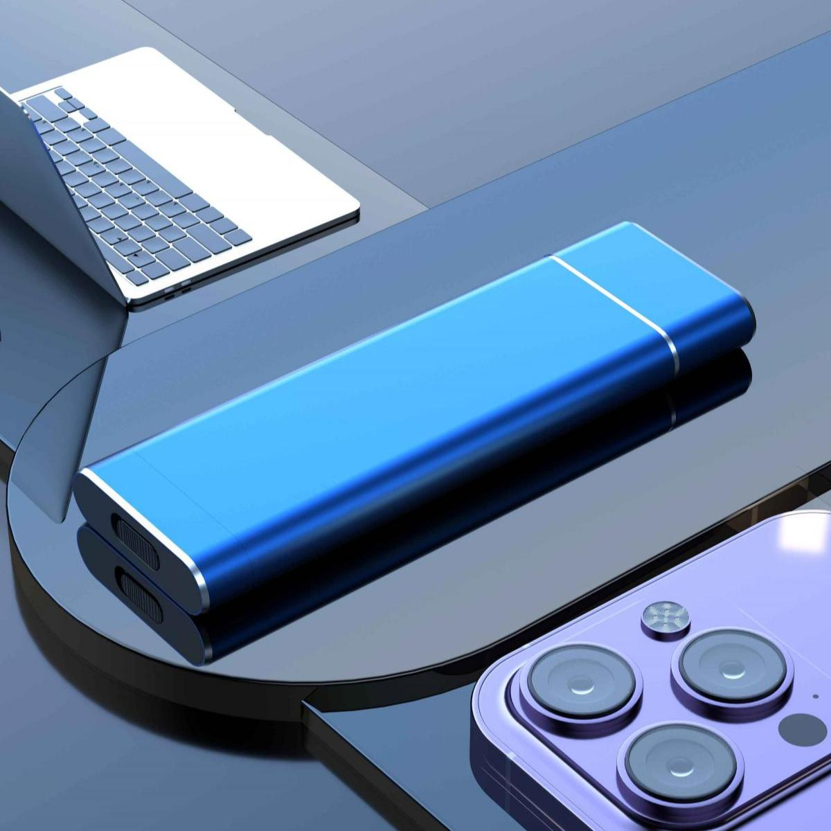 Blaue externe Festplatte mit Telefon und Laptop auf reflektierender Oberfläche.