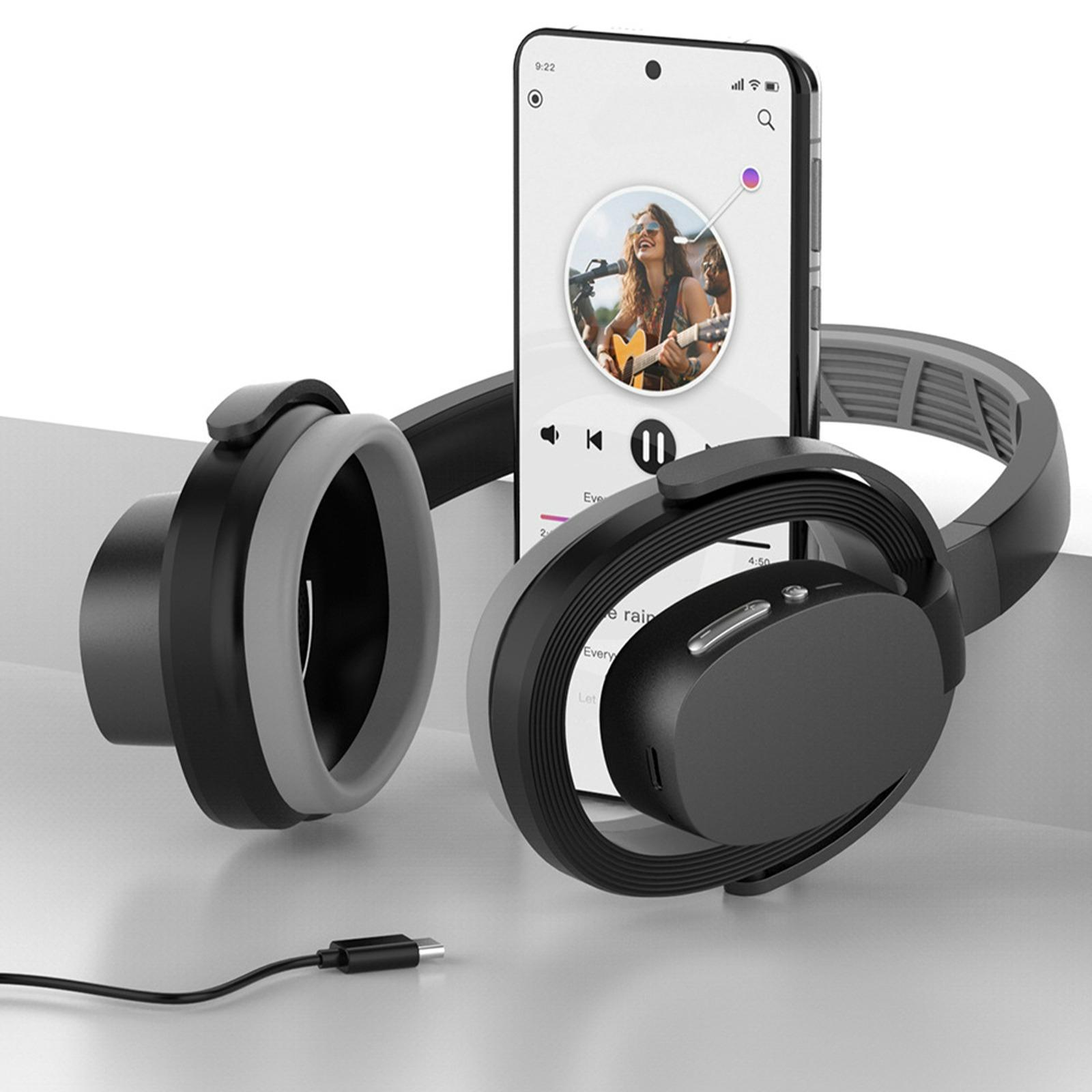 Schwarz-graue Kopfhörer neben einem Telefon, das eine Person beim Gitarrespielen zeigt. Ein Ladekabel ist vorhanden.