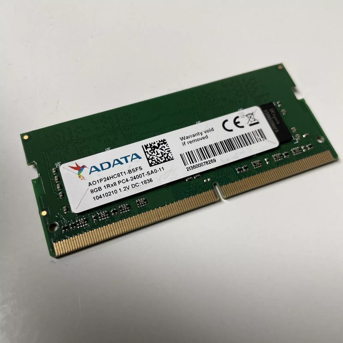 Un modulo RAM verde con etichetta ADATA e un adesivo bianco con testo. Ha connettori dorati.