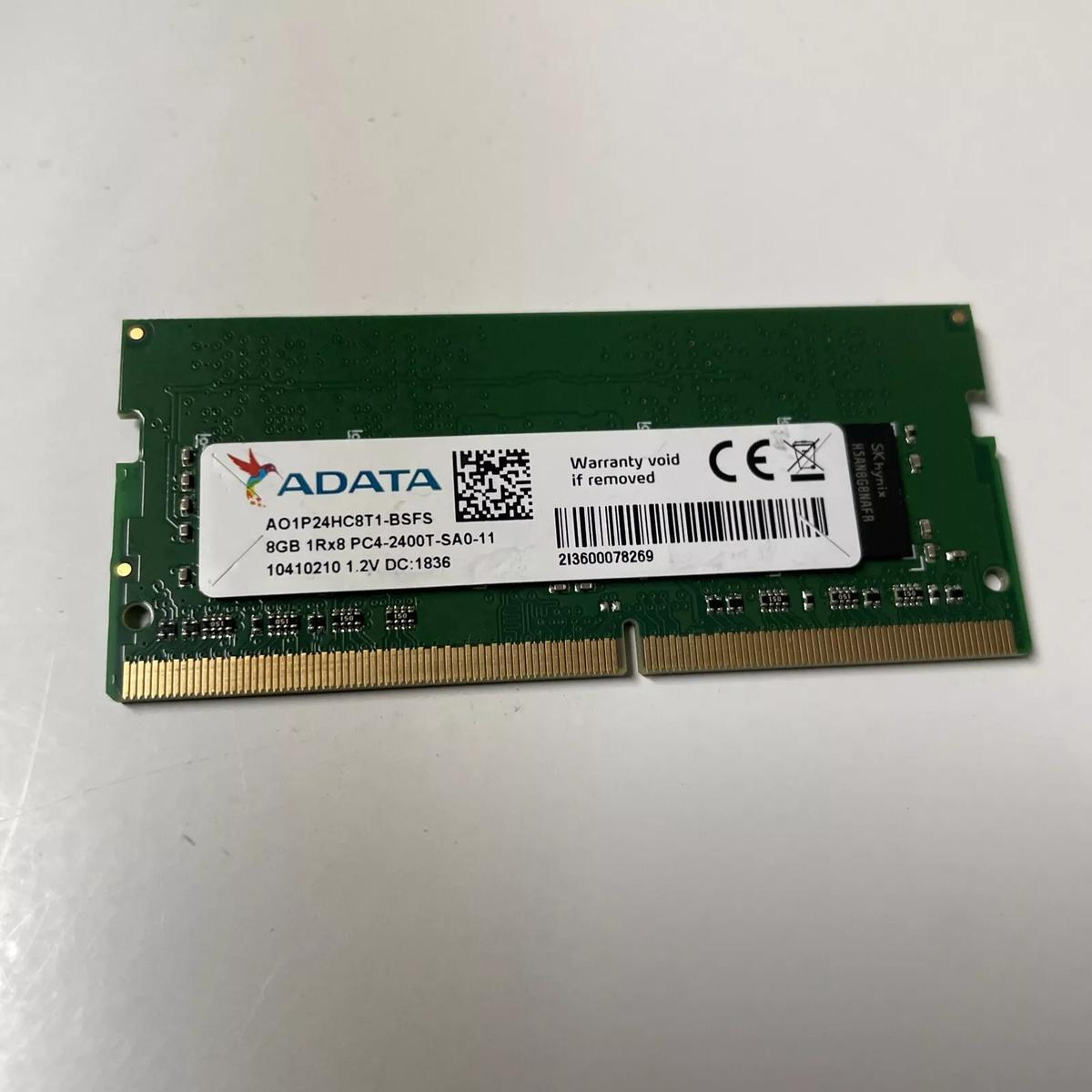 Un modulo RAM ADATA verde con etichette e un codice a barre, su una superficie bianca.