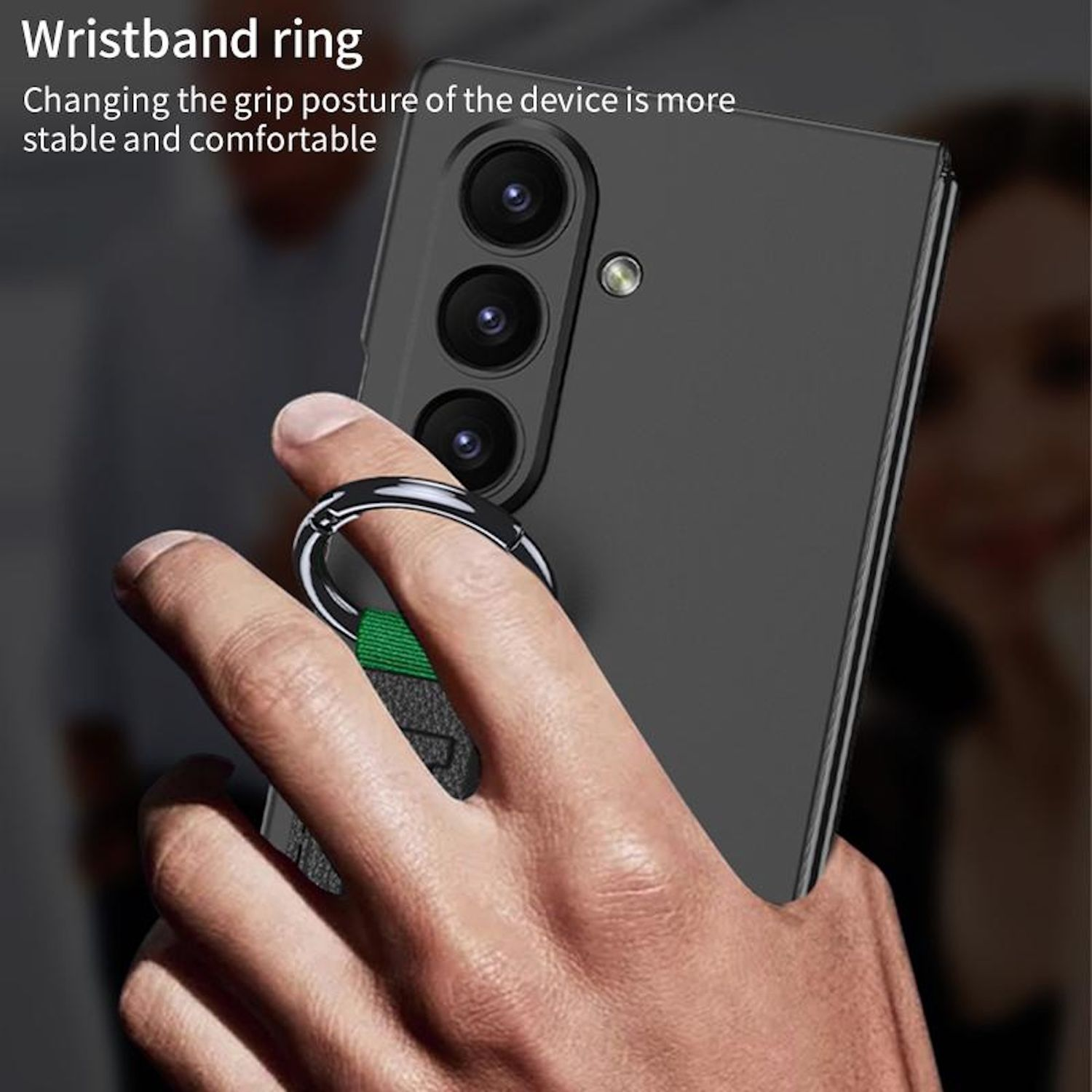 Una mano sostiene un teléfono con un anillo. El teléfono es negro y tiene tres cámaras. El anillo es plateado.
