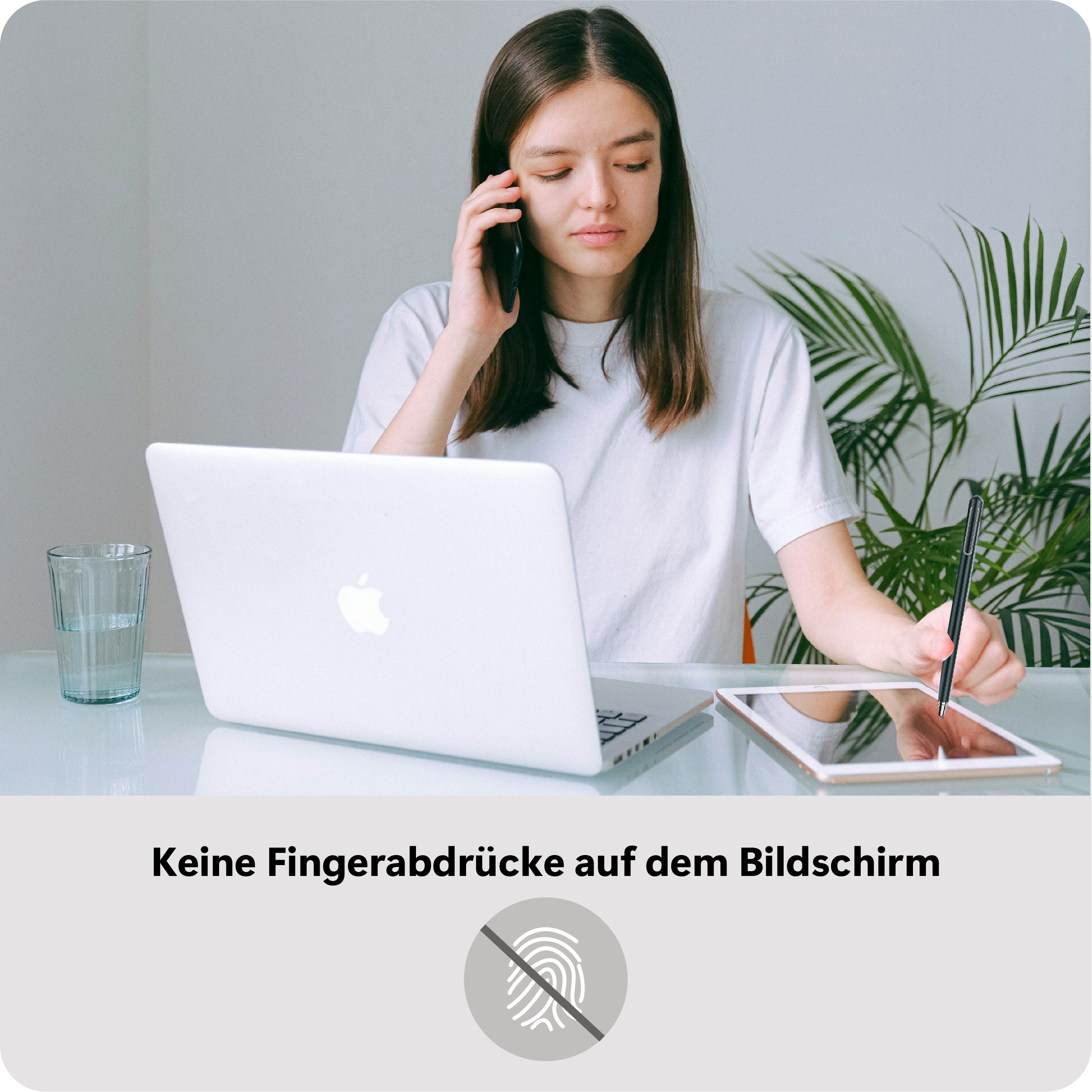 Eine Frau benutzt einen Stift auf einem Tablet, mit einem Laptop und einem Glas Wasser auf dem Tisch. Sie telefoniert auch.