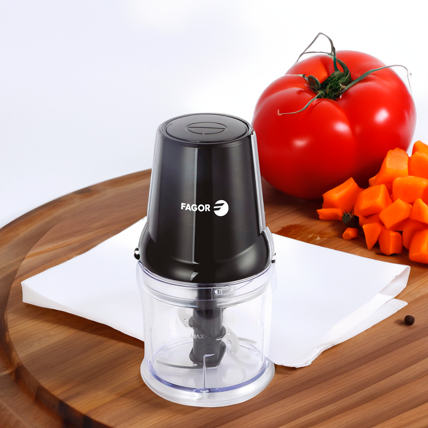 Licuadora con ingredientes. Licuadora negra, tomate y zanahorias picadas. Tabla de madera.
