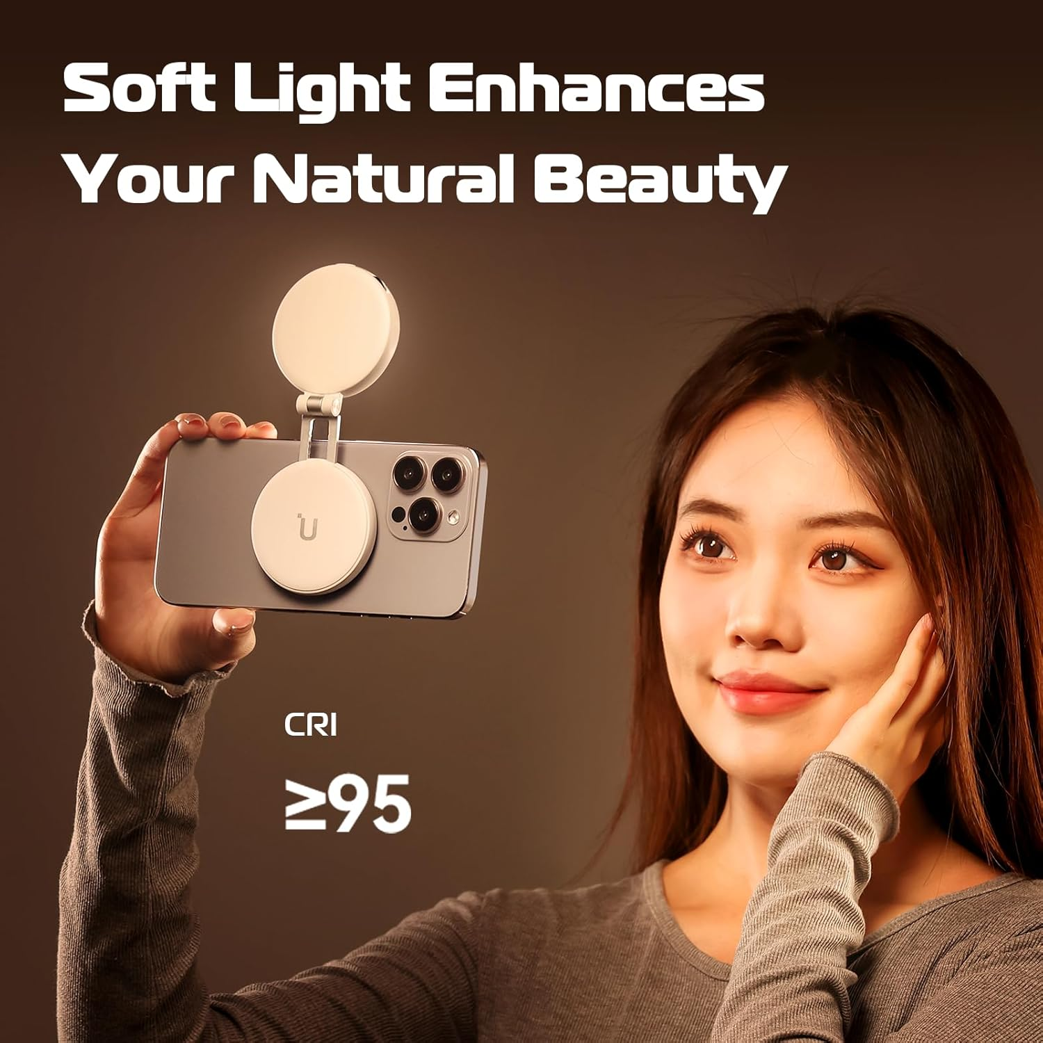 L'image montre une femme tenant un téléphone avec une fixation de lumière, mettant l'accent sur la lumière douce et la beauté naturelle.