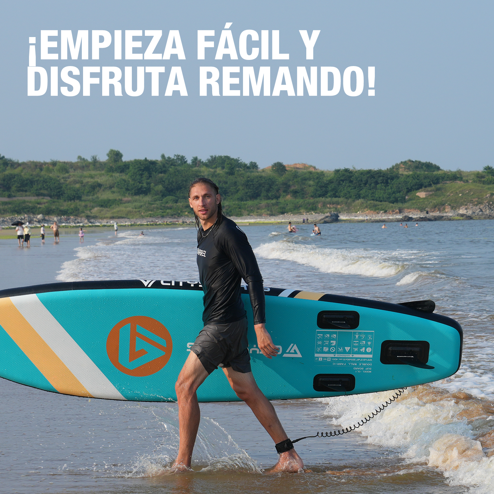 Hombre caminando con paddleboard en el mar. Camina en el agua con tabla azul y naranja.
