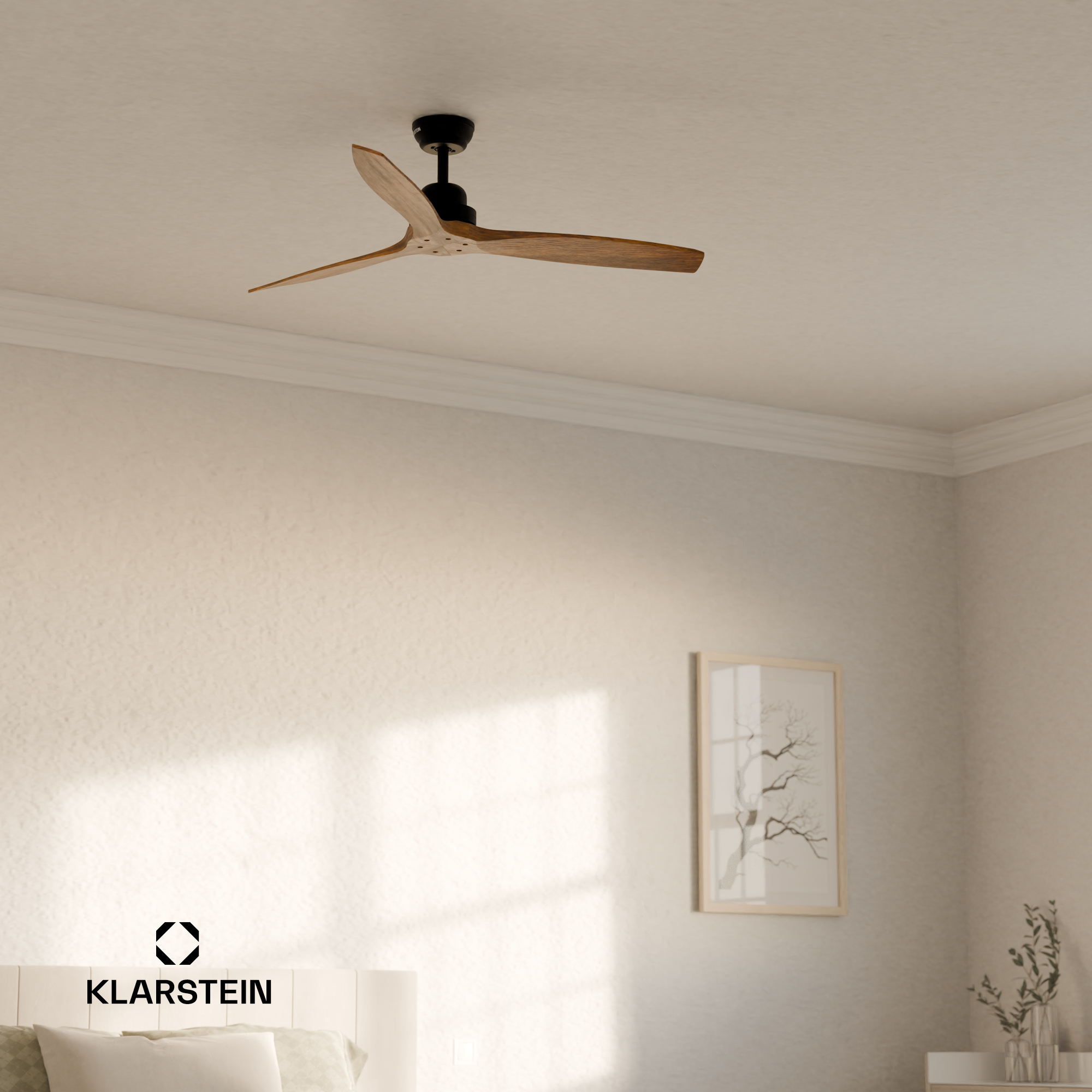 Un ventilatore a soffitto con tre pale in legno, motore nero, in una stanza con un letto e un quadro incorniciato.