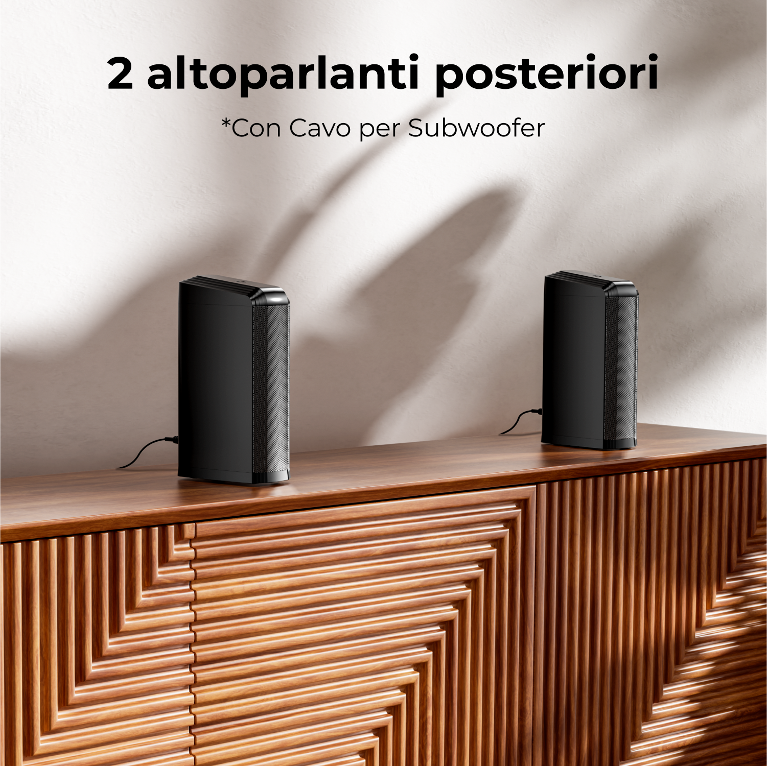 Due altoparlanti neri su un mobile di legno. Ogni altoparlante ha un cavo. Il mobile ha un design geometrico.