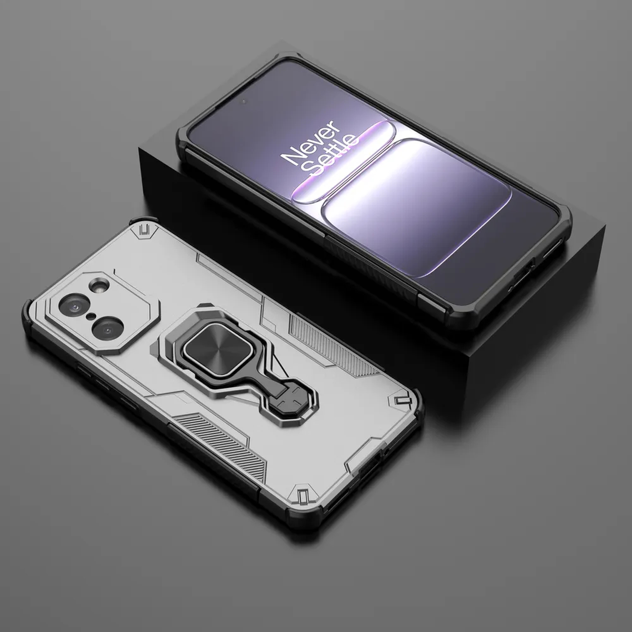 Deux téléphones avec coques, un argenté, un noir, tous deux avec anneaux, sur une surface sombre.