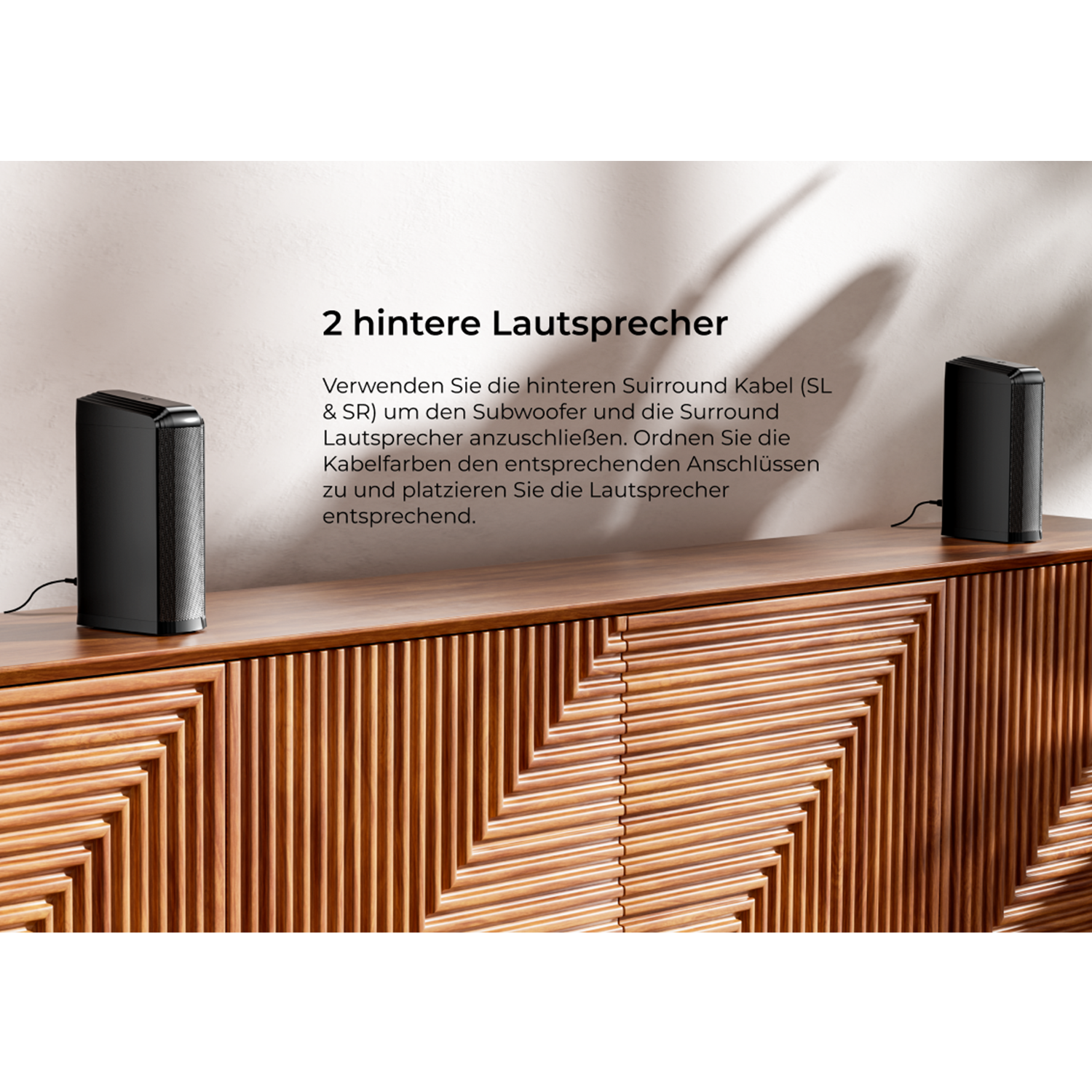 Zwei schwarze Lautsprecher auf einem Holzschrank. Text beschreibt den Anschluss von Subwoofer und Lautsprechern.
