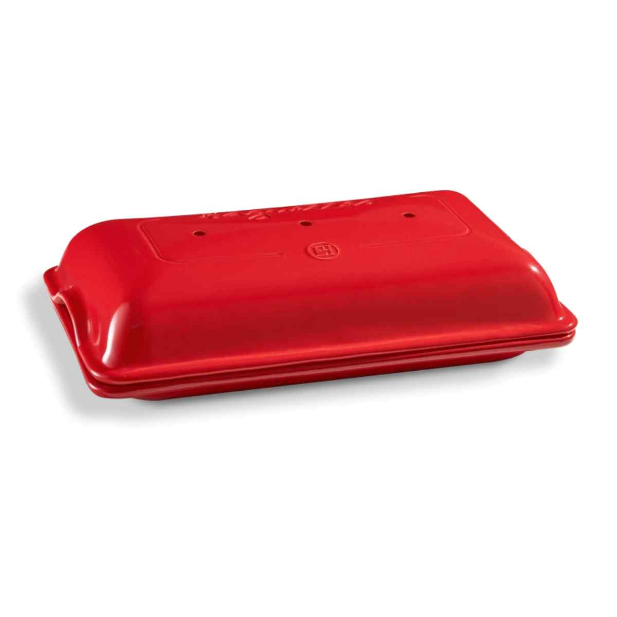 Czerwony ceramiczny piekarnik do chleba z zamkniętą pokrywą. Tło jest białe.