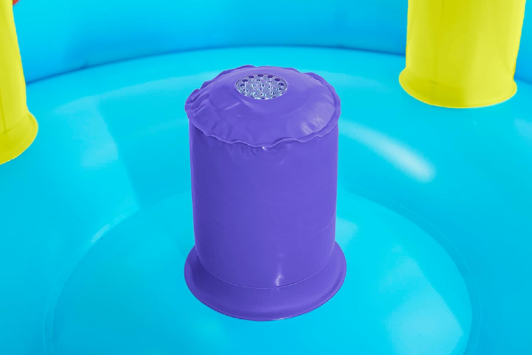 Un primo piano di un giocattolo gonfiabile viola con uno sfondo azzurro. Strutture gialle ai lati.