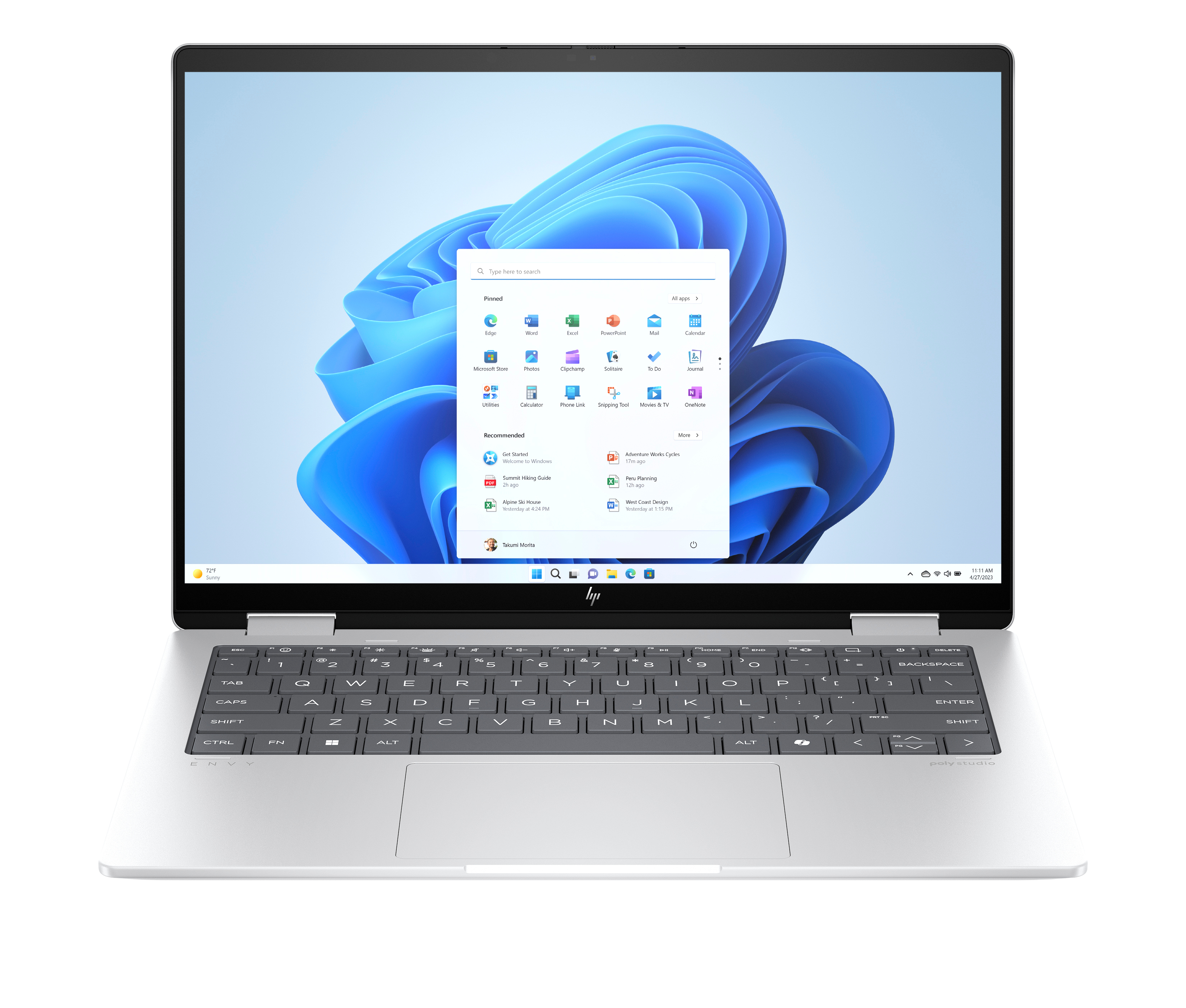 Srebrny laptop otwarty, widoczny interfejs Windows 11. Klawiatura na pierwszym planie. Ekran pokazuje aplikacje i pasek wyszukiwania.