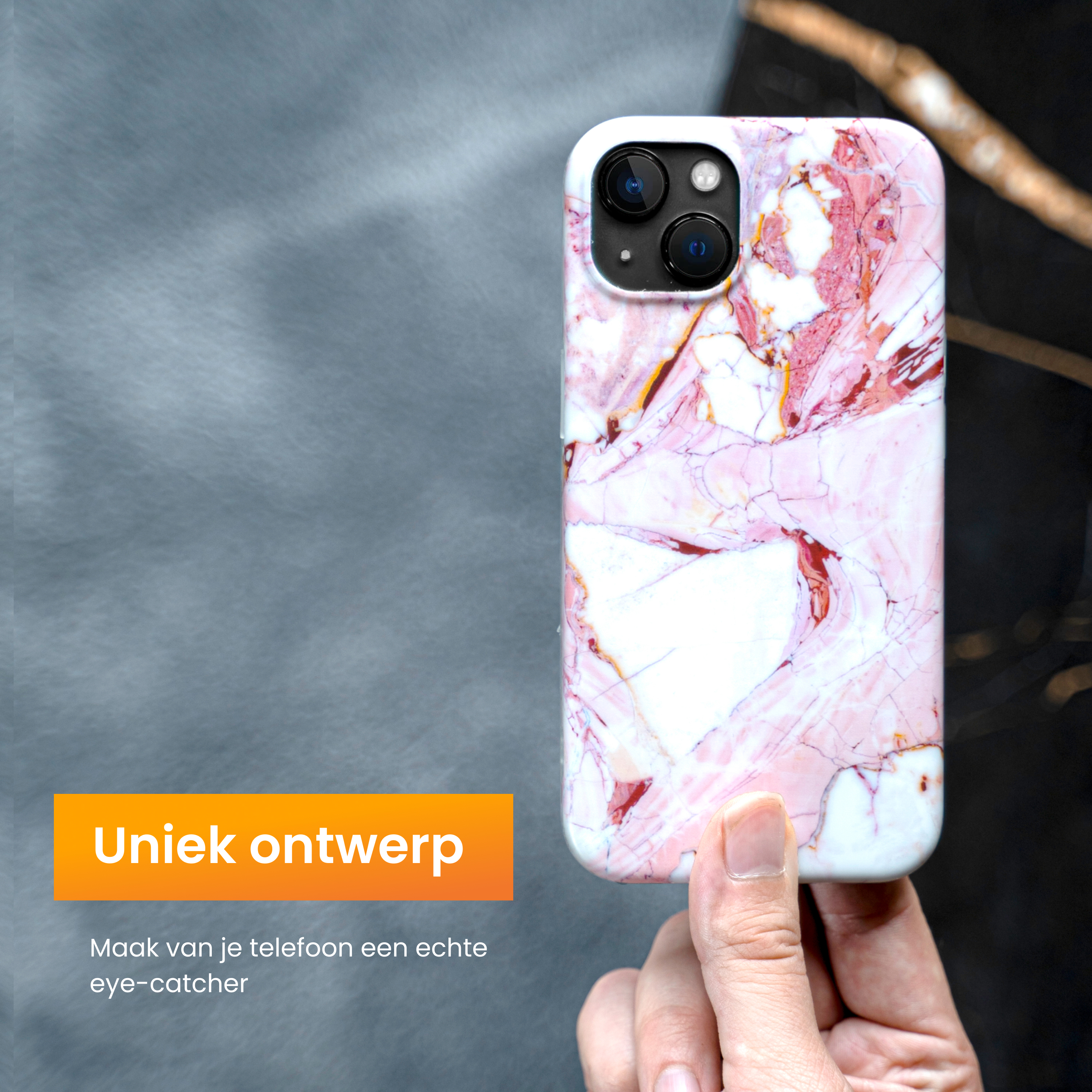 A hand holds a phone case with a marble design. It is pink and white. The background is gray and black.