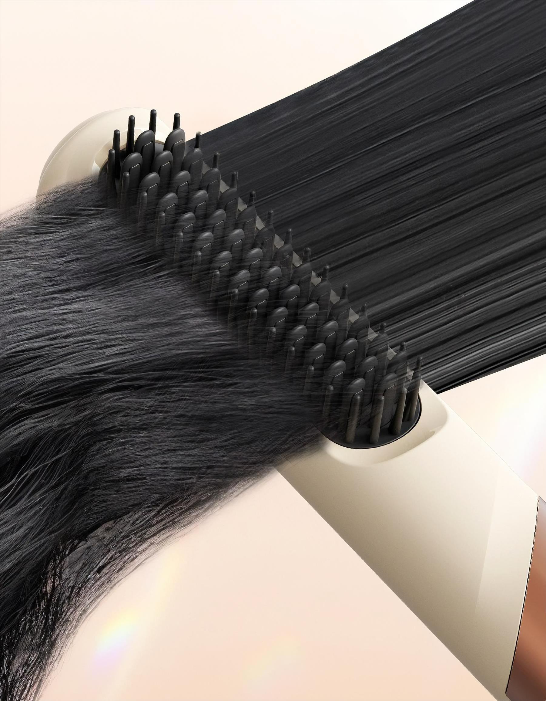 Ein Haarglätter bürstet durch schwarzes Haar. Der Glätter ist cremefarben mit schwarzen Borsten.