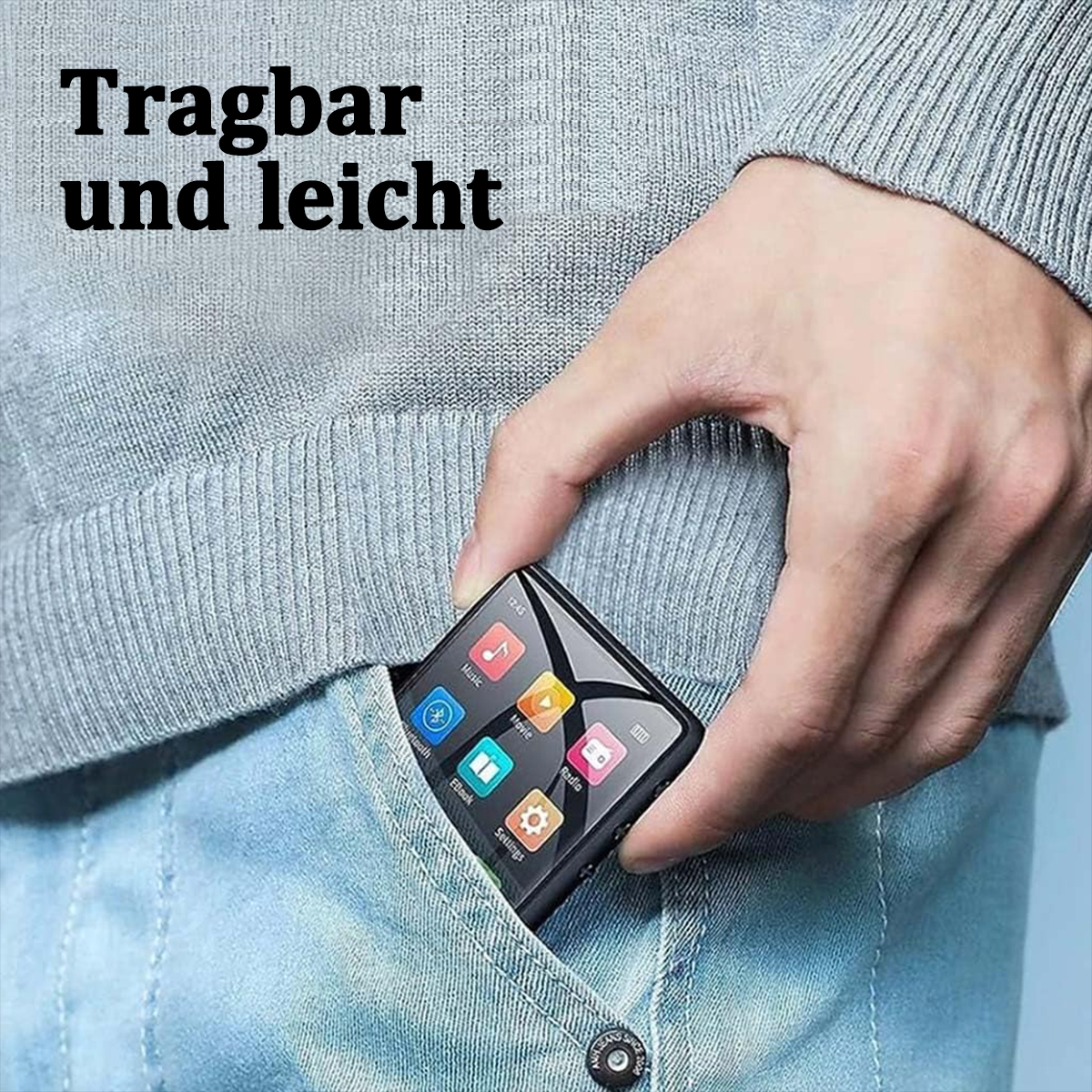 Die Hand einer Person hält einen kleinen, schwarzen Mediaplayer aus einer Jeanstasche. Der Bildschirm zeigt farbige Symbole, Text oben lautet 'Tragbar und leicht'.