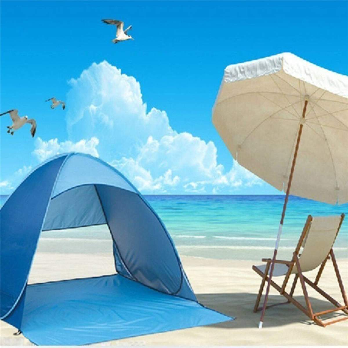 Strandszene: blaues Zelt, Sonnenschirm, Stuhl, fliegende Möwen, blaues Meer und Himmel. Weiße Wolken, Sand am Strand.