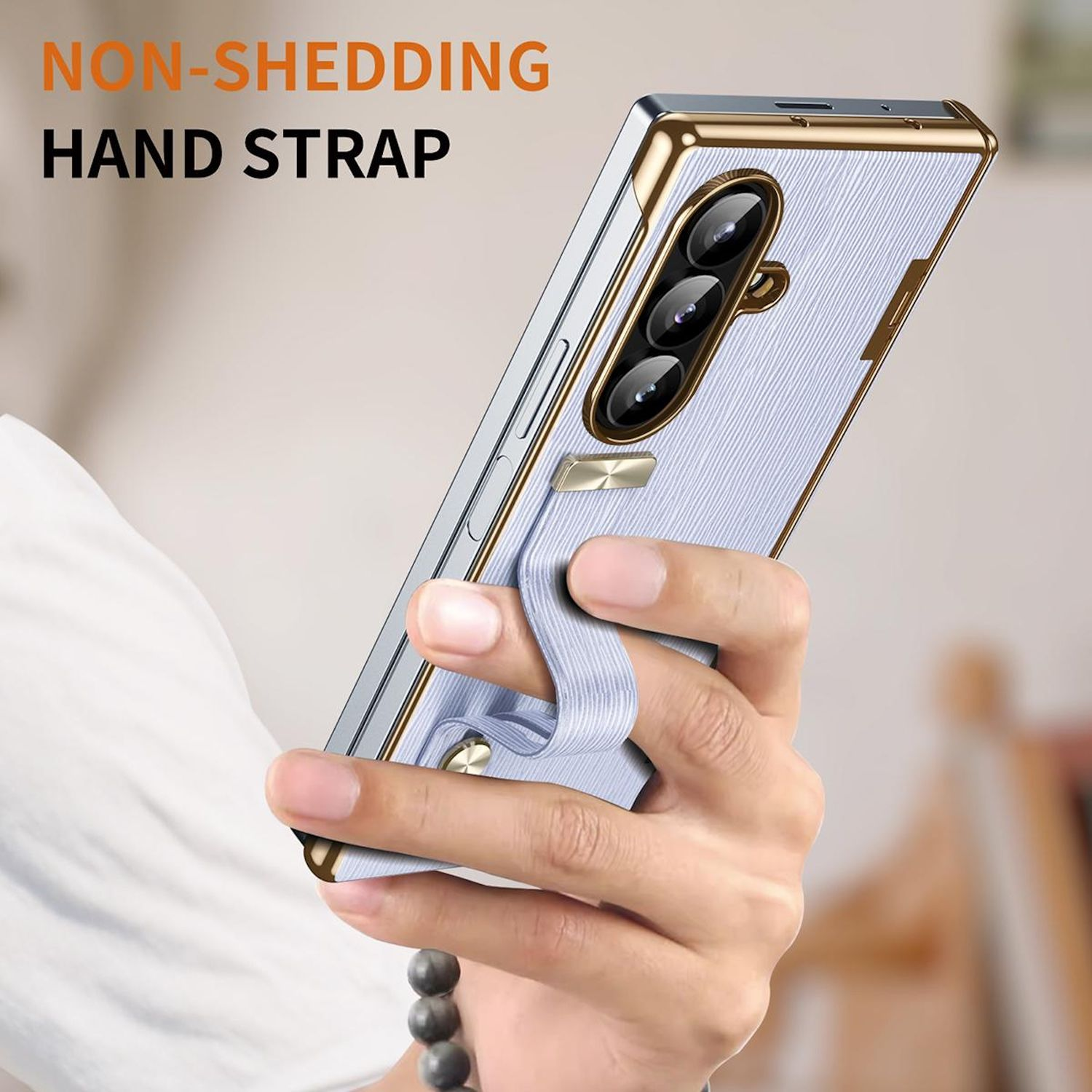 Eine Hand hält ein Smartphone in einer Schutzhülle mit Handschlaufe. Die Hülle ist hellblau und gold.