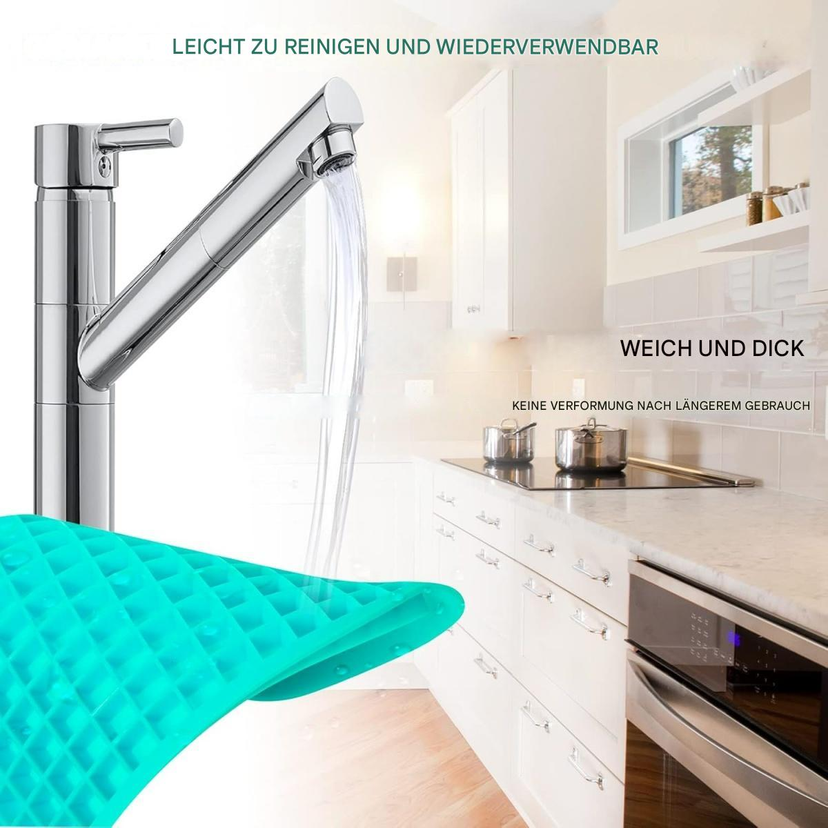Ein verchromter Wasserhahn, der Wasser in ein Waschbecken gießt. Eine türkisfarbene Matte mit Gittermuster im Vordergrund. Küchenschränke und Geräte im Hintergrund.