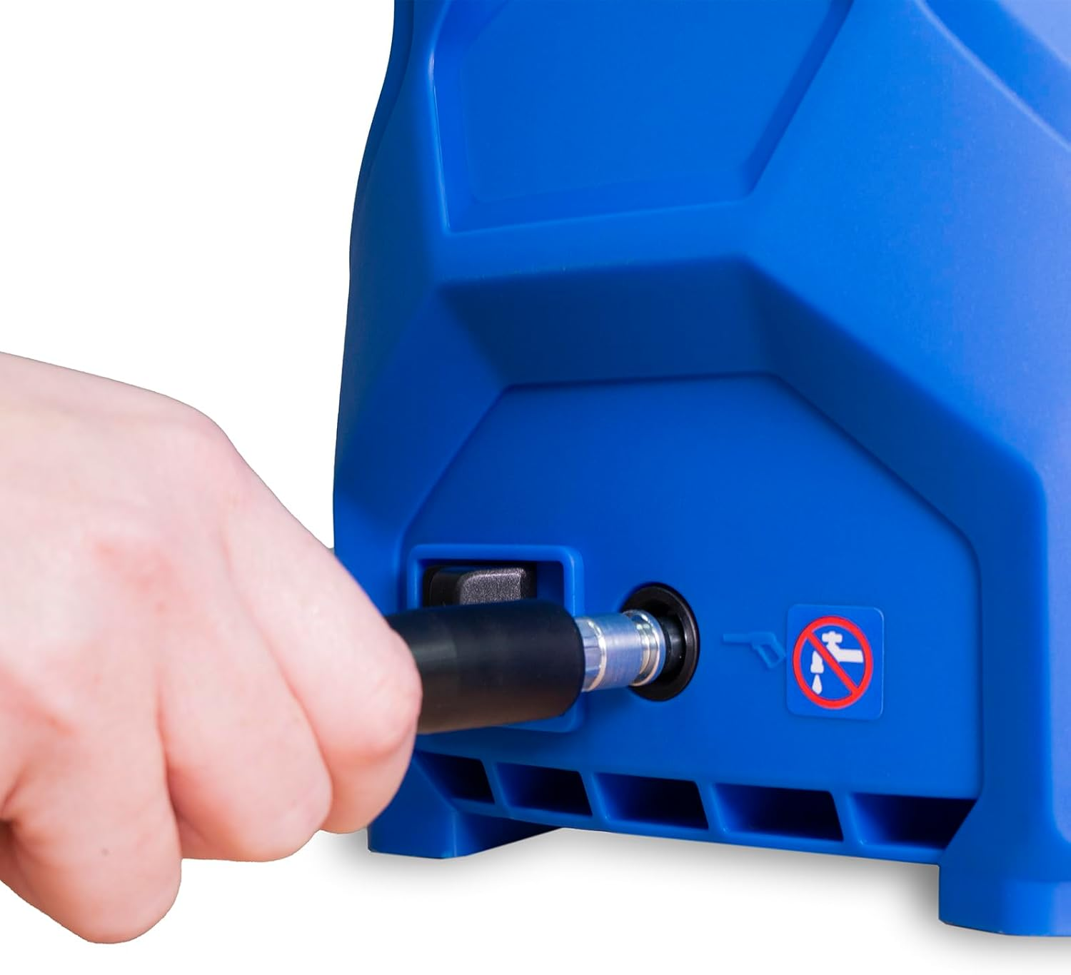 Una mano conecta una manguera negra a una máquina azul. La máquina tiene un letrero de prohibido el agua y un conector plateado.