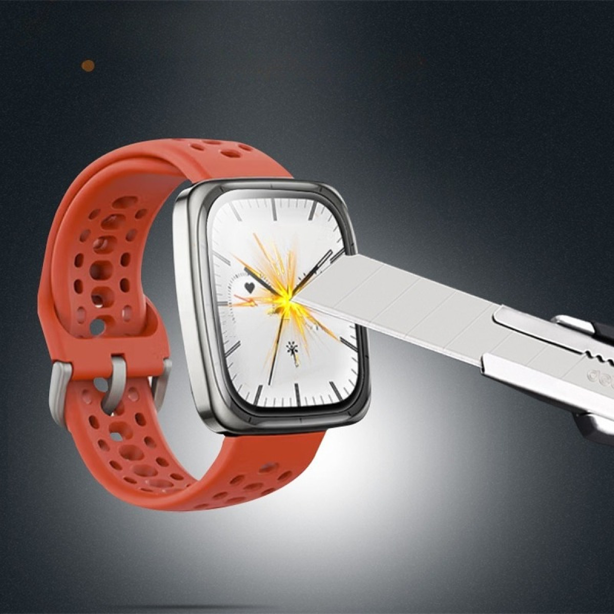Uno smartwatch arancione con cornice argentata viene tagliato con un taglierino. Il quadrante mostra l'ora e le icone.